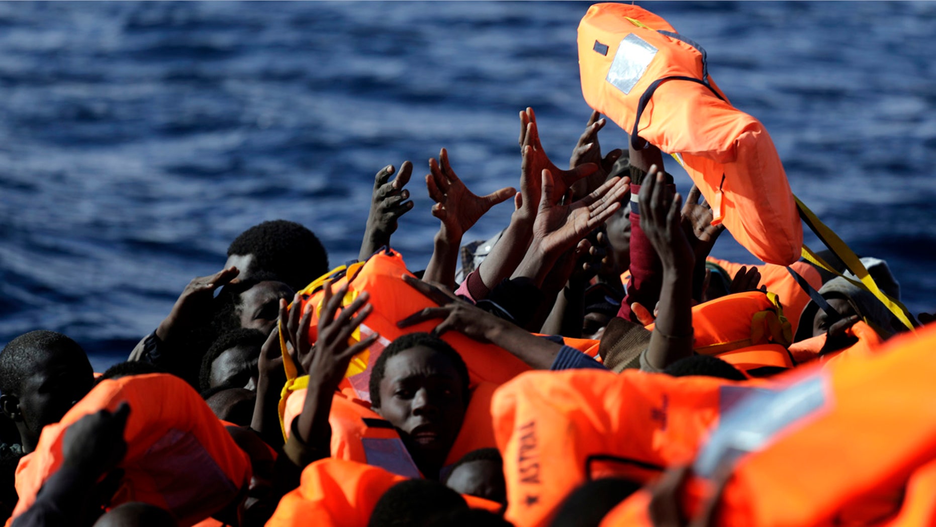 Jan. 27, 2017: Sub-Saharan migrants raise their hands to grab a life jacket as they are rescued by members of the Proactive Open Arms NGO, in the Mediterranean Sea north of Zumarah, Libya.