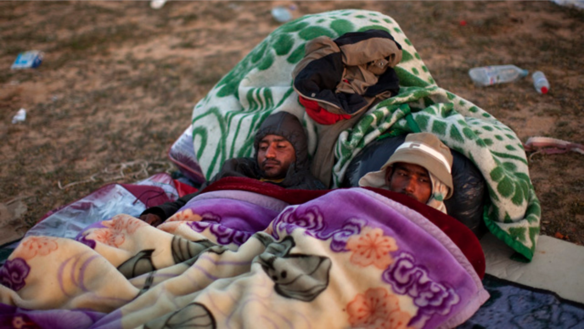 March 7: Men from Bangladesh, who used to work in Libya but recently fled the unrest, rest as they wait for their buses to be repatriated to their country, at a refugee camp at the Tunisia-Libya border, in Ras Ajdir, Tunisia. A top aid official says more than 213,000 foreign workers have fled Libya's violence and hundreds of thousands more are struggling to get out. The exodus is creating a humanitarian crisis across the border with Tunisia - another North African country in turmoil after an uprising in January that ousted its longtime leader. (AP)