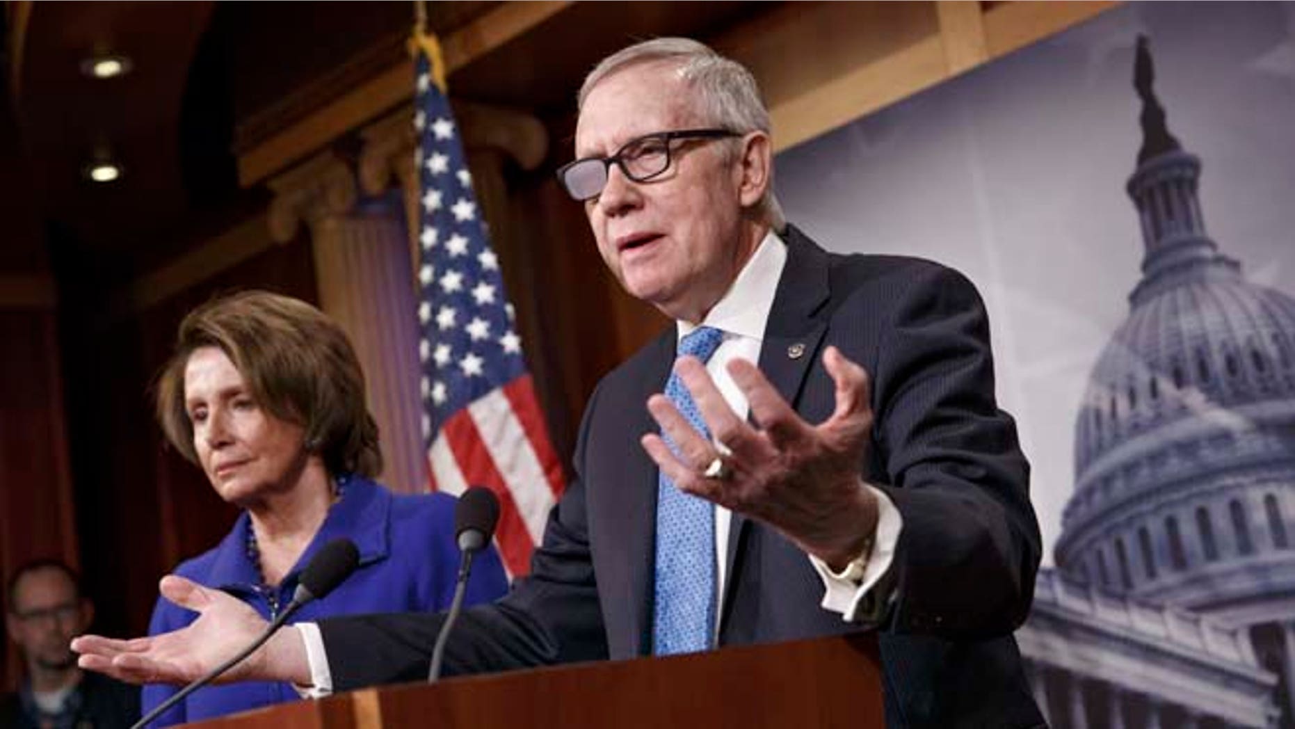 Feb. 26, 2015: Senate Minority Leader Harry Reid of Nev., accompanied by House Minority Leader Nancy Pelosi of Calif., gestures during a news conference on Capitol Hill.