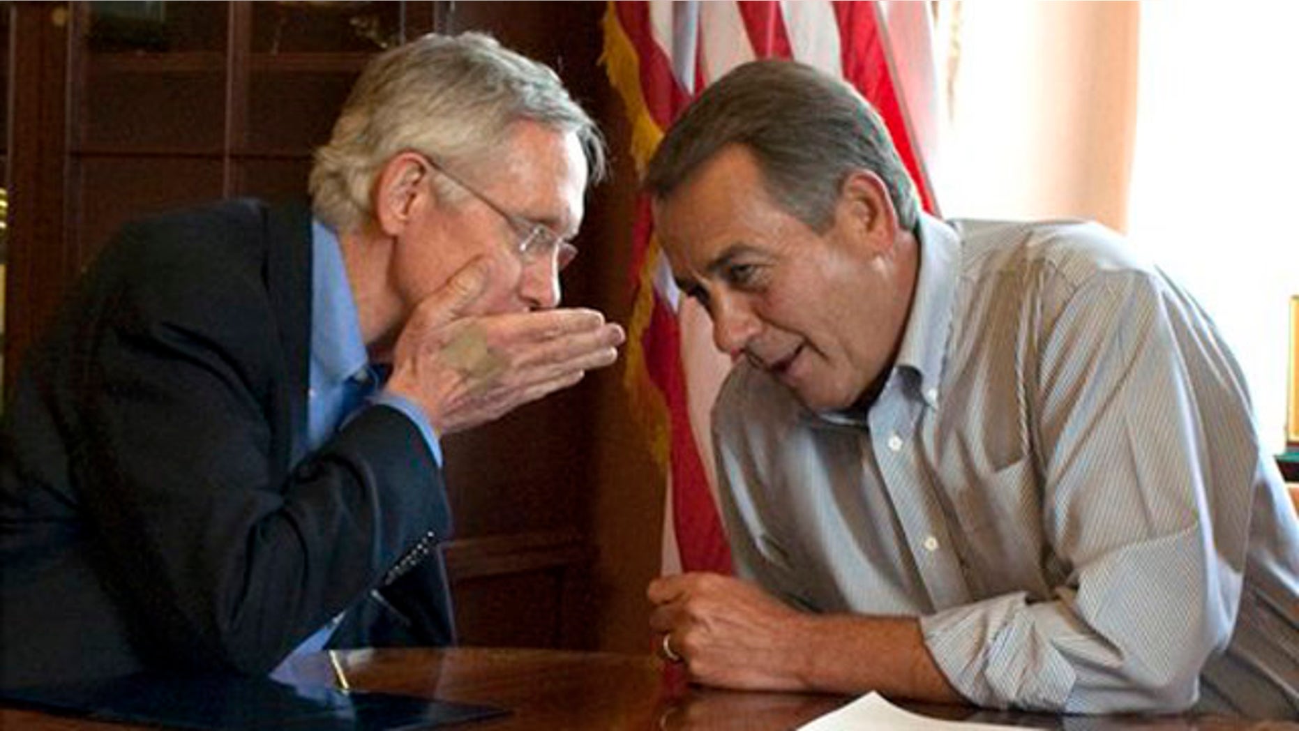 Senate Majority Leader Harry Reid holds his hand up as he whispers to House Speaker John Boehner during a photo opportunity in the House Speaker's office in Washington July 23.