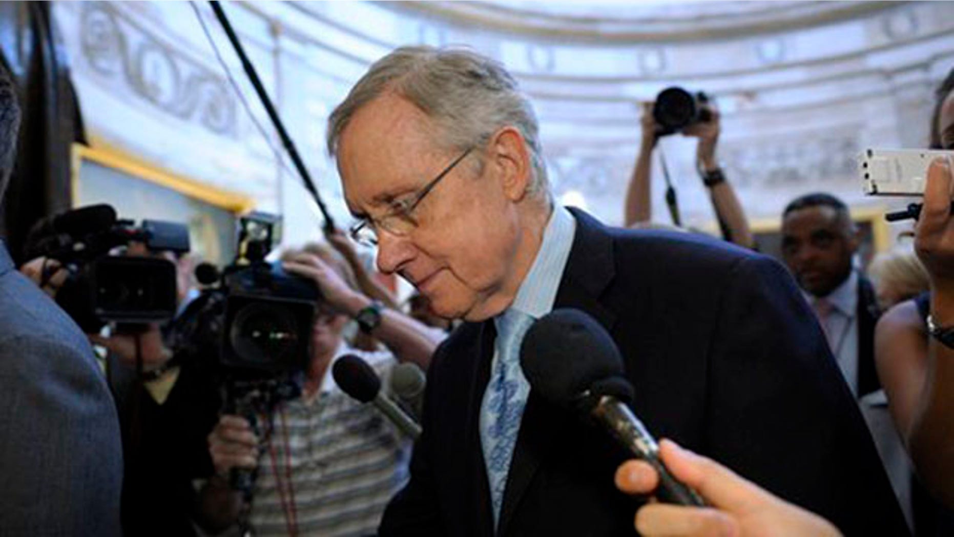 Senate Majority Leader Harry Reid is followed by reporters as he walks through the Capitol Rotunda on Capitol Hill July 31.