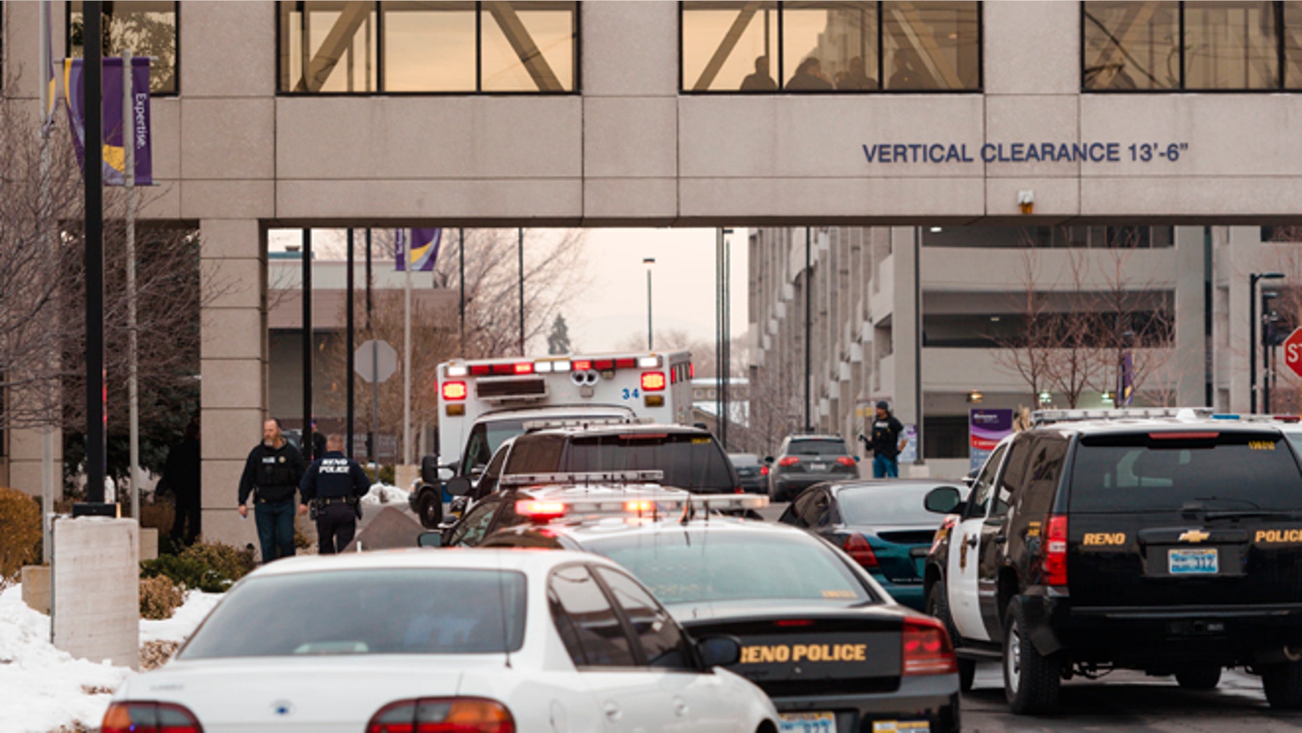Dec. 17, 2013: Officers gather in front of the Renown Regional Medical Center after a lone gunman shot and injured three people, one fatally, before killing himself in Reno, Nev.