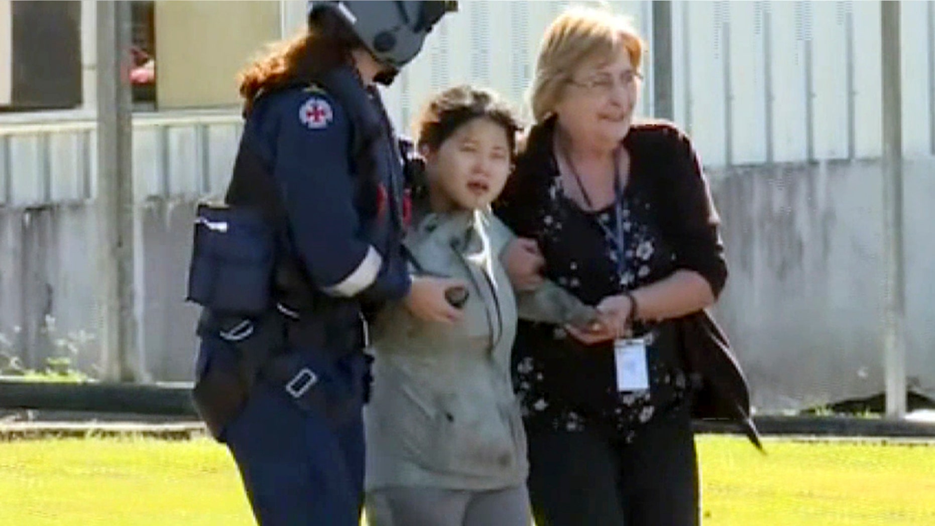 In this image taken from the Australian Broadcasting Corporation video, South Korean backpacker Joohee Han, 25, center, is assisted to a hospital after being rescued by helicopter, Thursday, June 7, 2018, in Tully, Queensland, Australia.