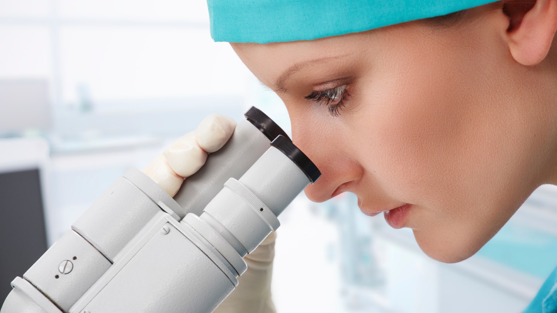 Woman scientist working with microscope at laboratory