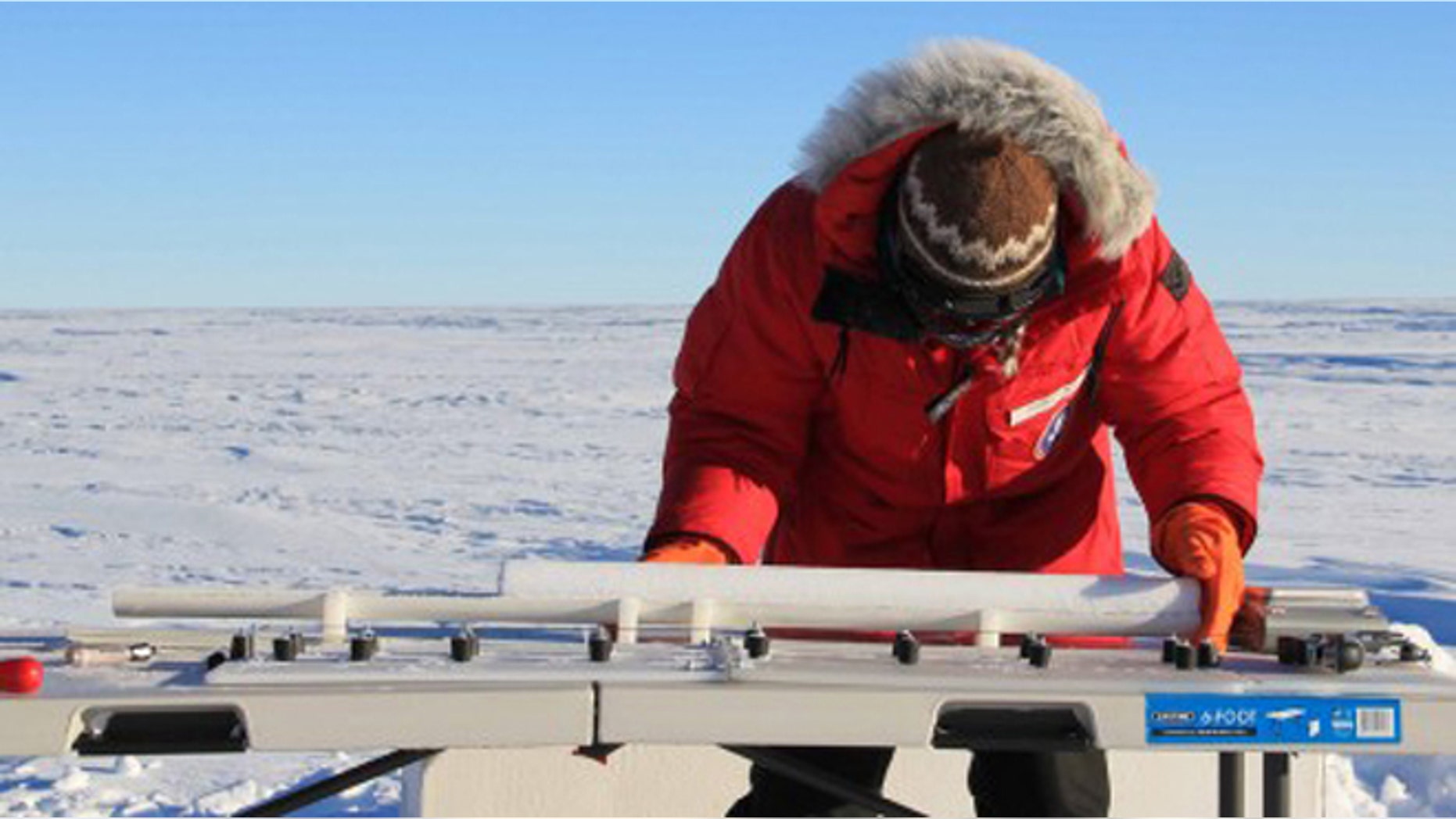 A researcher from the University of Copenhagen examines an ice core from the West Antarctic Ice Sheet.