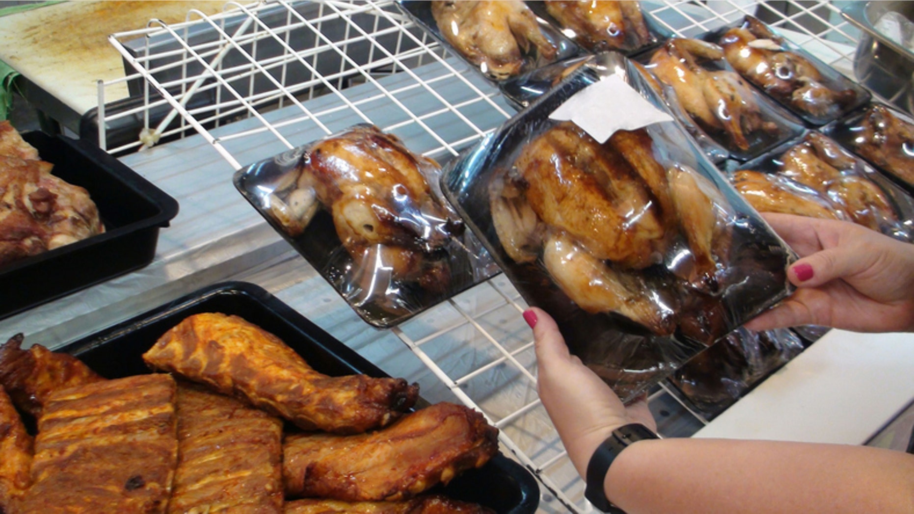 Young Woman's Hand Choosing Roasted Chicken On The Market