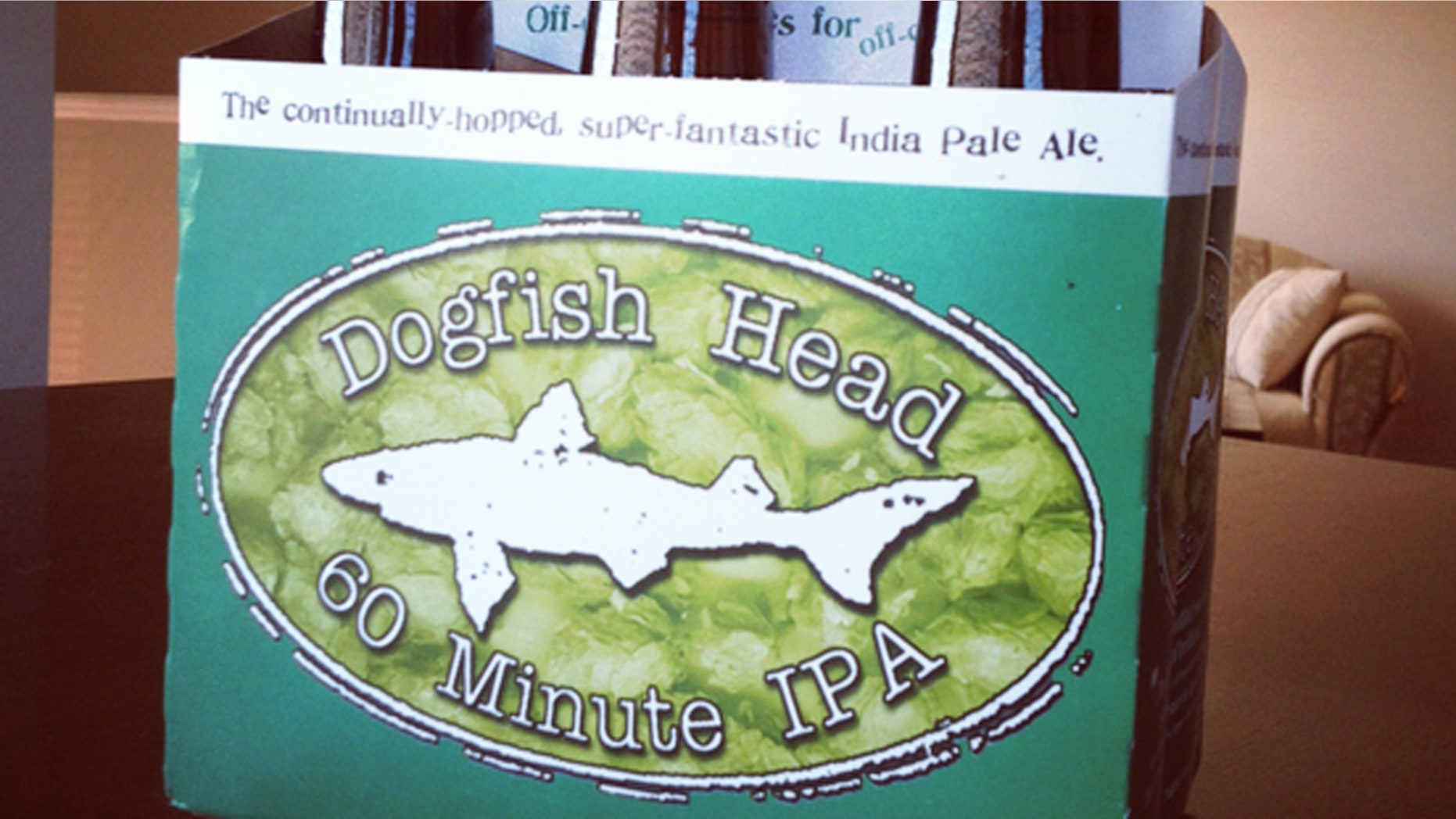 Dartmouth, Nova Scotia, Canada - August 29, 2012: A six-pack of Dogfish Head 60 Minute IPA Beer sitting on a table inside a home. All six bottles are visible and unopened with Dogfish Head logo displayed on box. "Continually hopped, super-fantastic India Pale Ale" is also displayed.