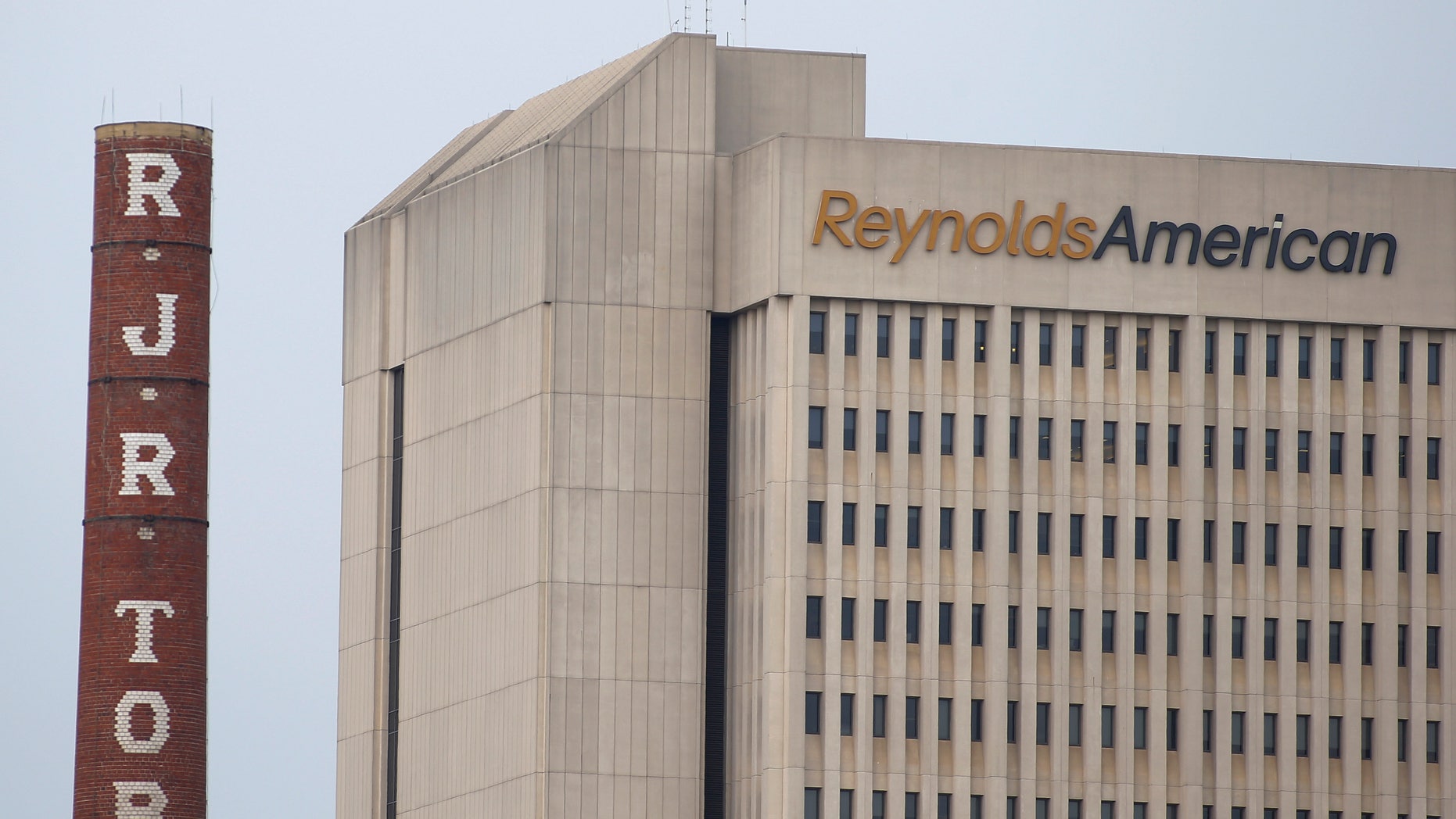 The headquarters of Reynolds American is seen next to the old R.J. Reynolds Tobacco smoke stacks from a previous manufacturing plant in downtown Winston-Salem, North Carolina May 23, 2014. REUTERS/Chris Keane
