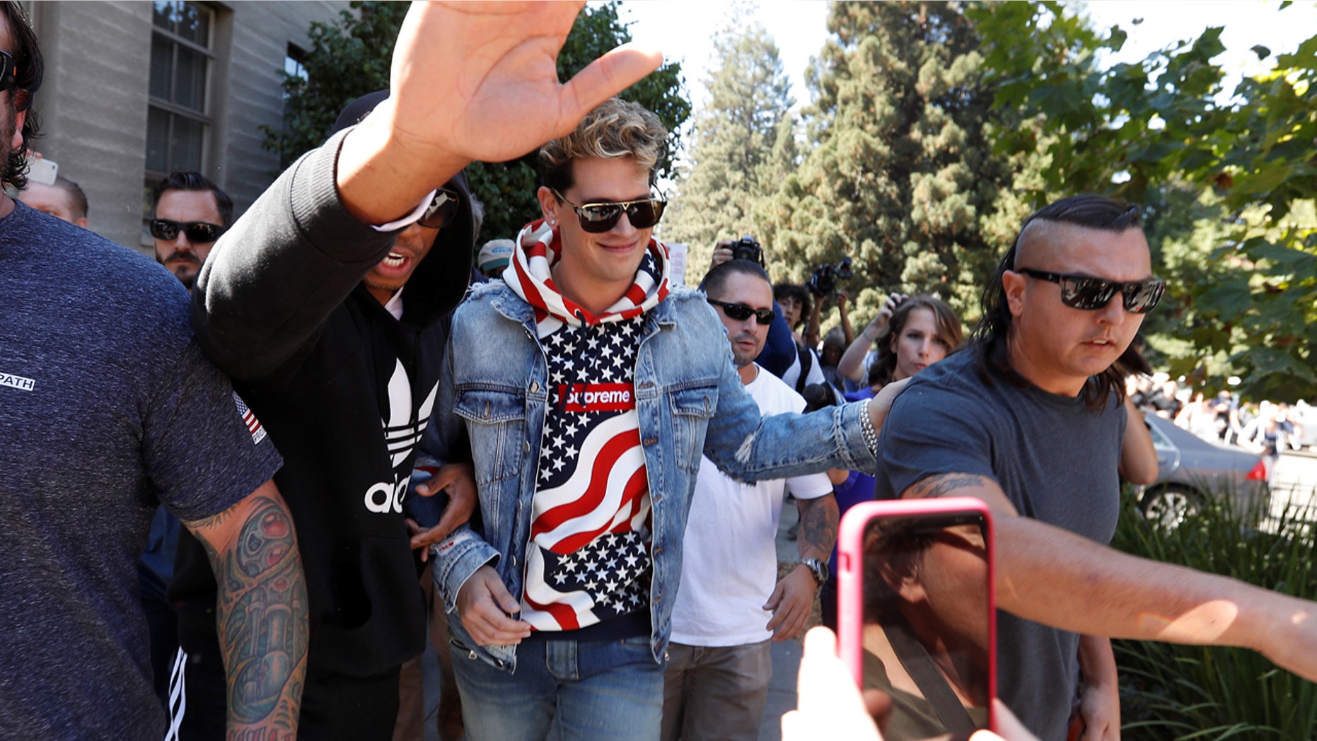 FILE 2017: Milo Yiannopoulos walks while being escorted away after speaking at the University of California in Berkeley