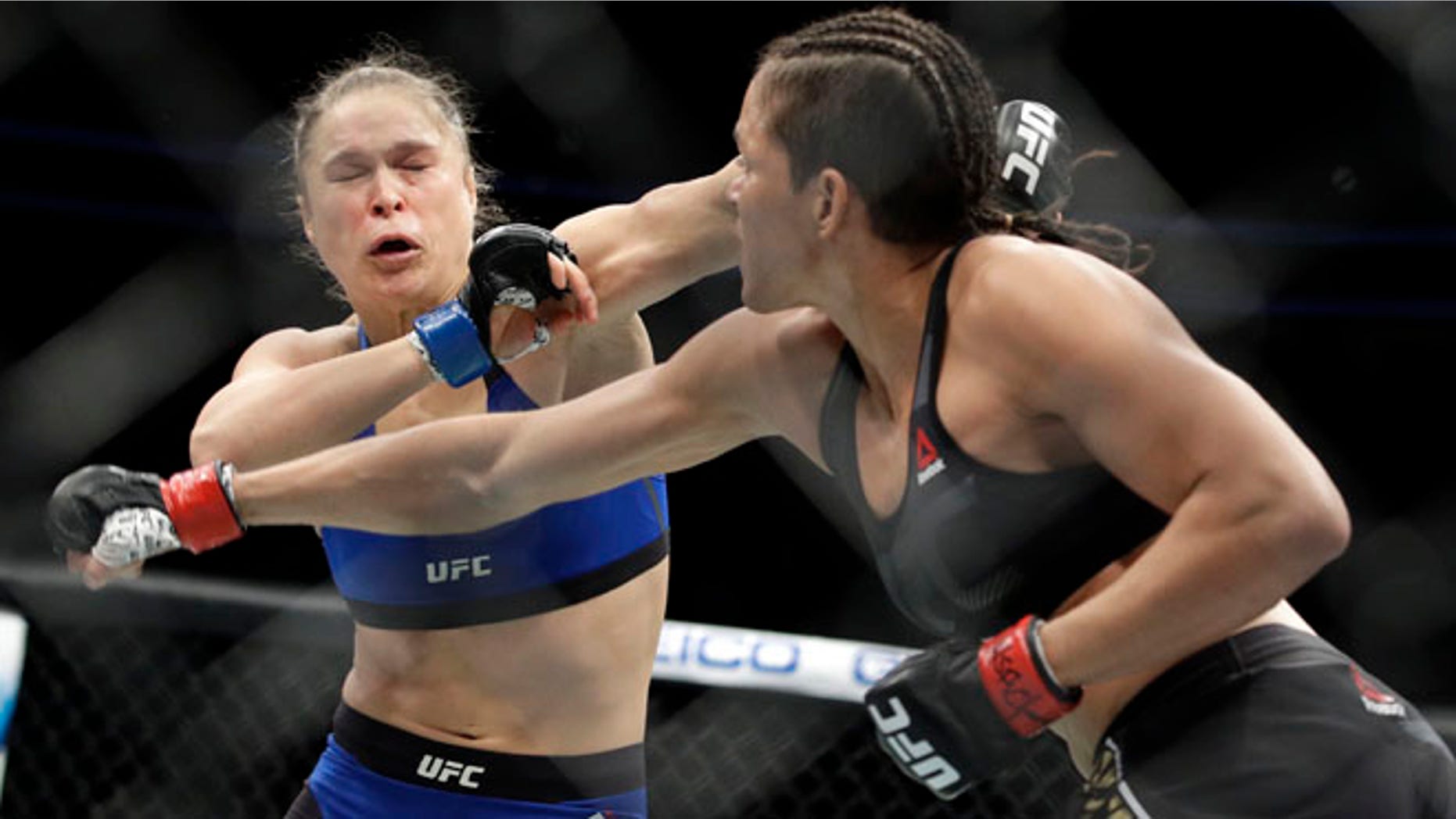 Amanda Nunes, right, throws a punch at Ronda Rousey in the first round of their women's bantamweight championship mixed martial arts bout at UFC 207, Friday, in Las Vegas.
