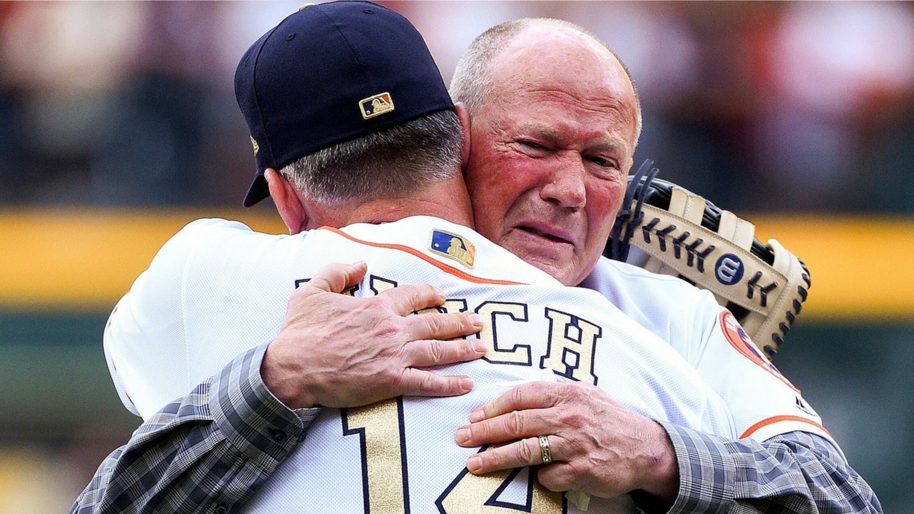 Rich Dauer embraces A.J. Hinch after throwing out the ceremonial first pitch.