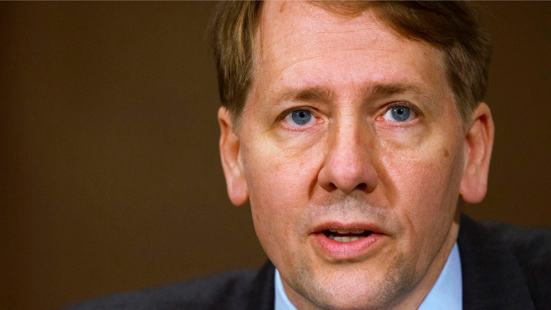 FILE - In this Nov. 12, 2013, file photo, Consumer Financial Protection Bureau Director Richard Cordray testifies before a Senate Committee on Banking hearing on Capitol Hill in Washington. Federal appeals judges are divided as they hear arguments over whether the president should be able to more easily fire the head of the government's consumer finance watchdog agency. The U.S. Court of Appeals for the District of Columbia, in a rare hearing by all its judges, took up the politically charged case involving the CFPB and the power of its director, Cordray. (AP Photo/Jacquelyn Martin, File)