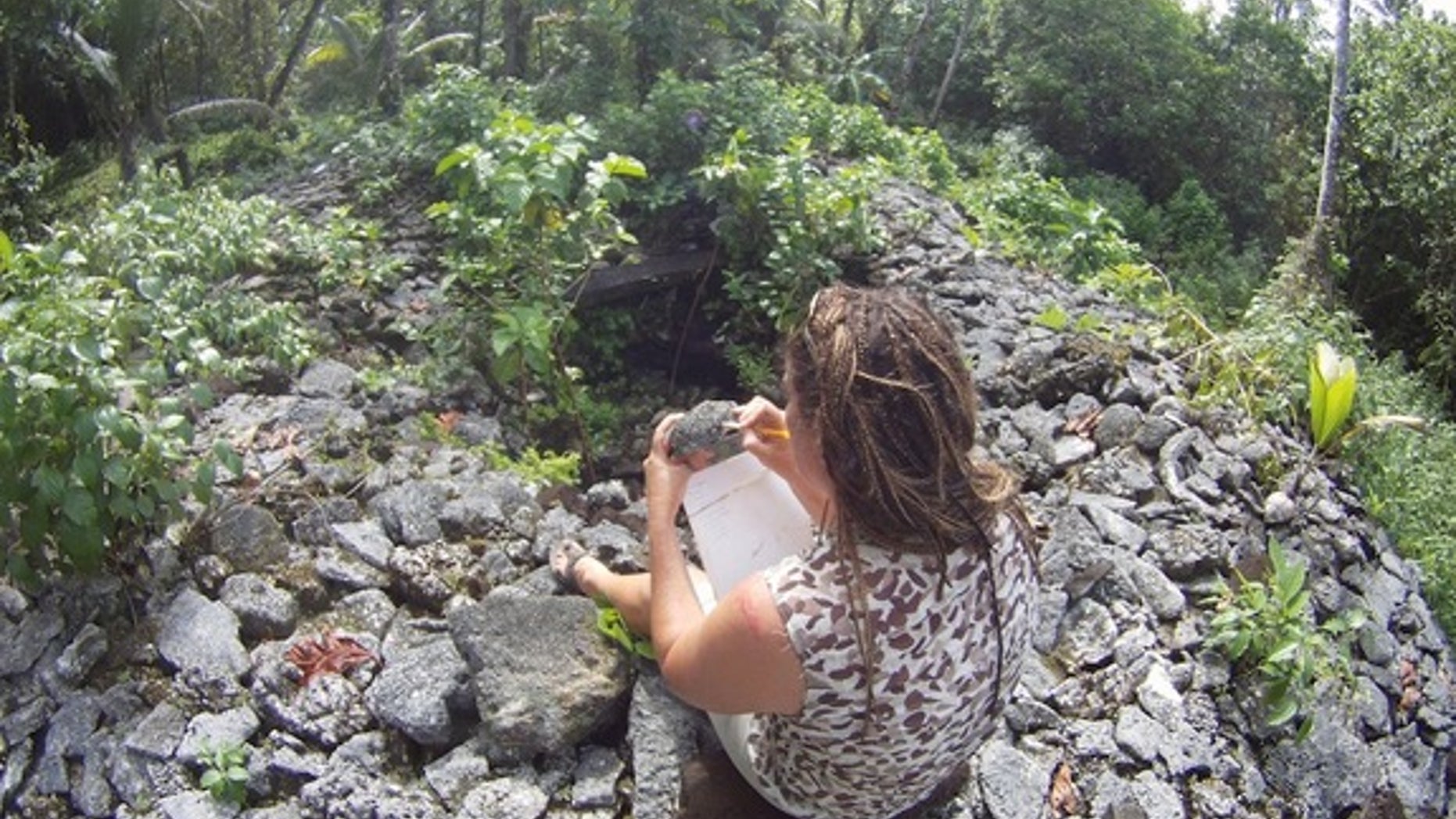 Researcher Zoe Richards inspects the corals used to build a royal tomb at Leluh known as Bat.