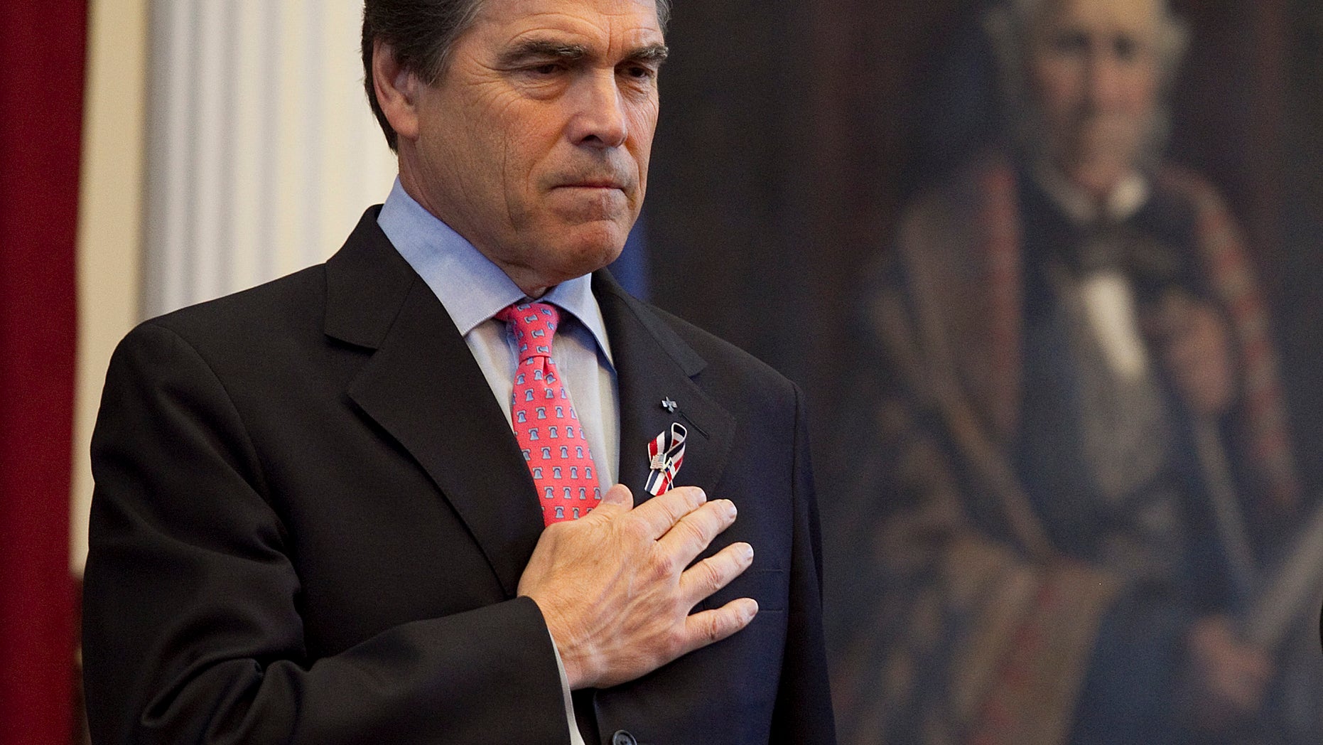Texas Gov. Rick Perry with his hand over his heart during a joint session of the Texas Legislature to honor fallen Texas servicemen in the House Chamber on Saturday, May 28, 2011 in Austin. (AP)