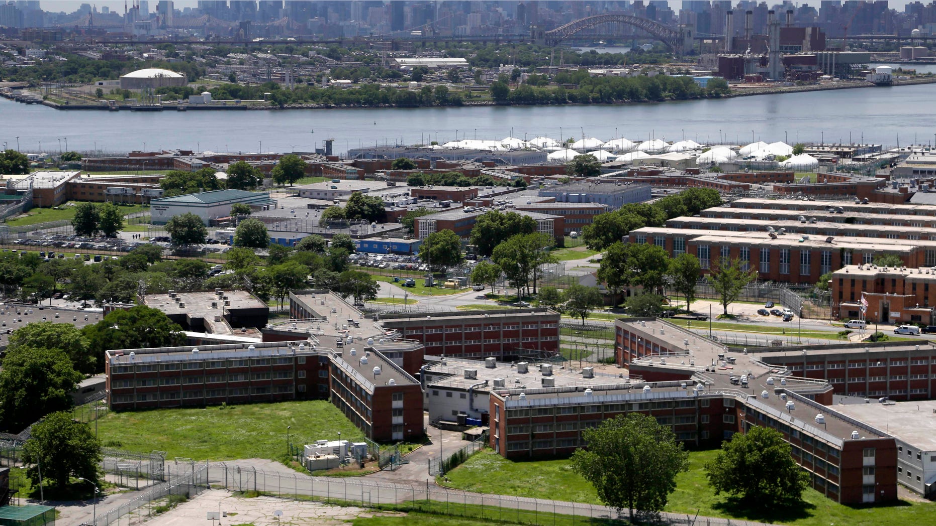 June 20, 2014: The sprawling Rikers Island jail complex stands in the foreground with the New York skyline in the climbing into the horizon