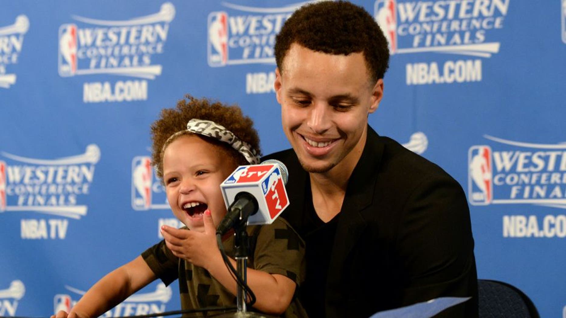 OAKLAND, CA - MAY 19: Stephen Curry #30 of the Golden State Warriors and his daughter Riley talking with the media at a press conference after the game against the Houston Rockets during Game One of the Western Conference Finals during the NBA Playoffs on May 19, 2015 at ORACLE Arena in Oakland, California. NOTE TO USER: User expressly acknowledges and agrees that, by downloading and or using this Photograph, user is consenting to the terms and conditions of the Getty Images License Agreement. Mandatory Copyright Notice: Copyright 2015 NBAE (Photo by Noah Graham/NBAE via Getty Images)