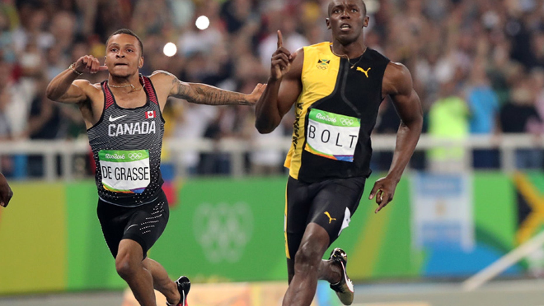Jamaica's Usain Bolt celebrates as he crosses the line to win gold in the men's 100-meter final with Canada's Andre de Grasse during the athletics competitions of the 2016 Summer Olympics at the Olympic stadium in Rio de Janeiro, Brazil, Sunday, Aug. 14, 2016.