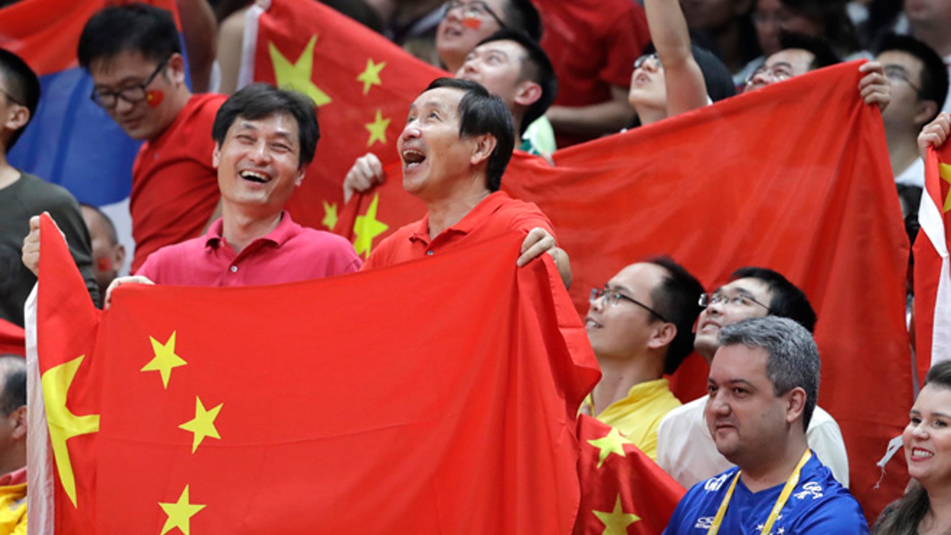 Fans hold the flag of China during a women's gold medal volleyball match between China and Serbia at the 2016 Summer Olympics in Rio de Janeiro, Brazil, Saturday, Aug. 20, 2016.
