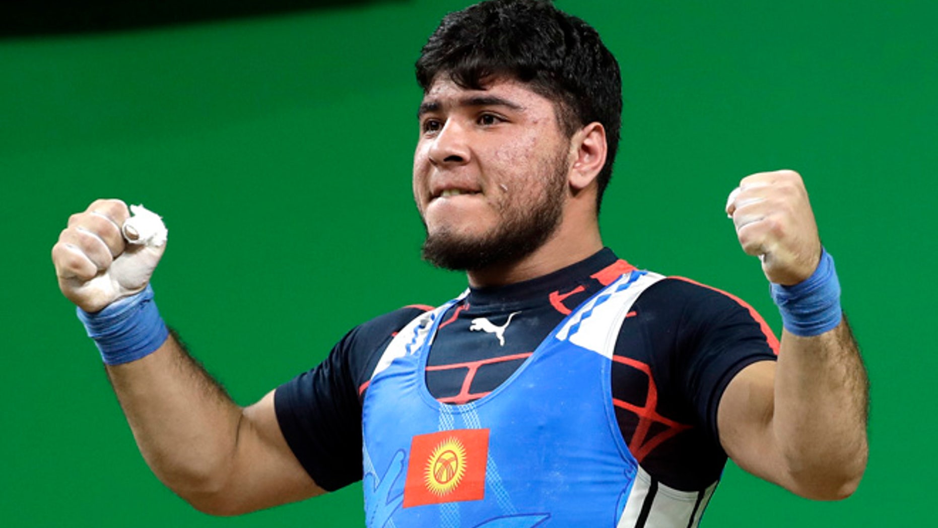 Izzat Artykov, of Kyrgystan, celebrates after a lift in the men's 69kg weightlifting competition at the 2016 Summer Olympics in Rio de Janeiro, Brazil, Tuesday, Aug. 9, 2016. (AP Photo/Mike Groll)