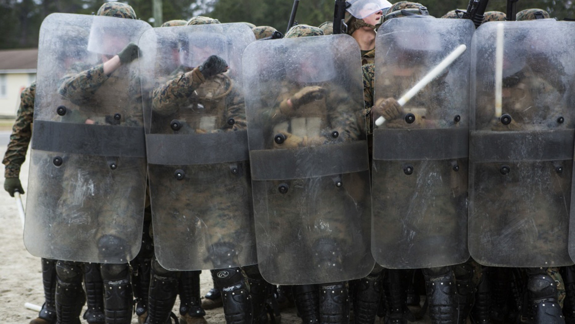U.S. Marines with Battalion Landing Team, 1st Battalion, 6th Marine Regiment, 22nd Marine Expeditionary Unit (MEU), hold riot shields to prevent injury during a simulated riot at Camp Lejeune, N.C., Jan. 22, 2016. The Marines participated in the course to ensure mission readiness and to improve their ability to maintain control during a riot. (Credit: U.S. Marine Corps)