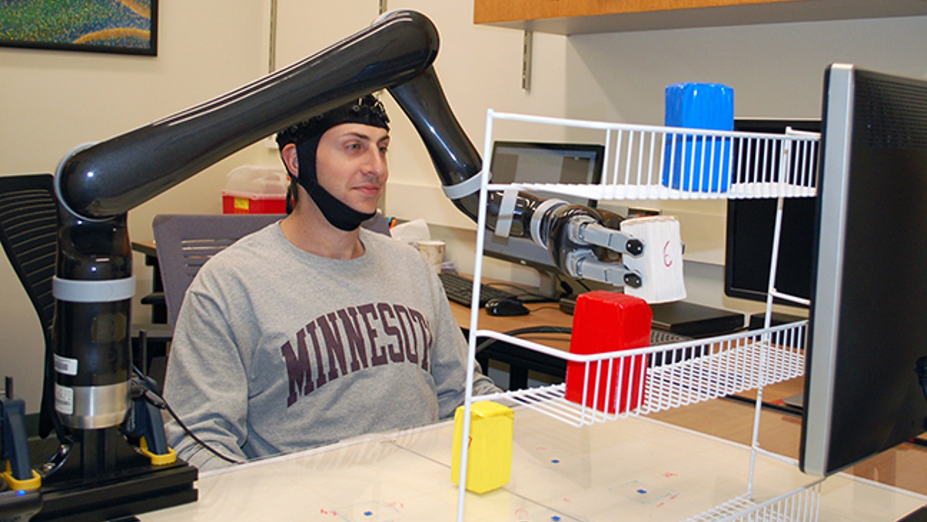 Research subjects at the University of Minnesota fitted with a specialized noninvasive brain cap were able to move the robotic arm just by imagining moving their own arms.