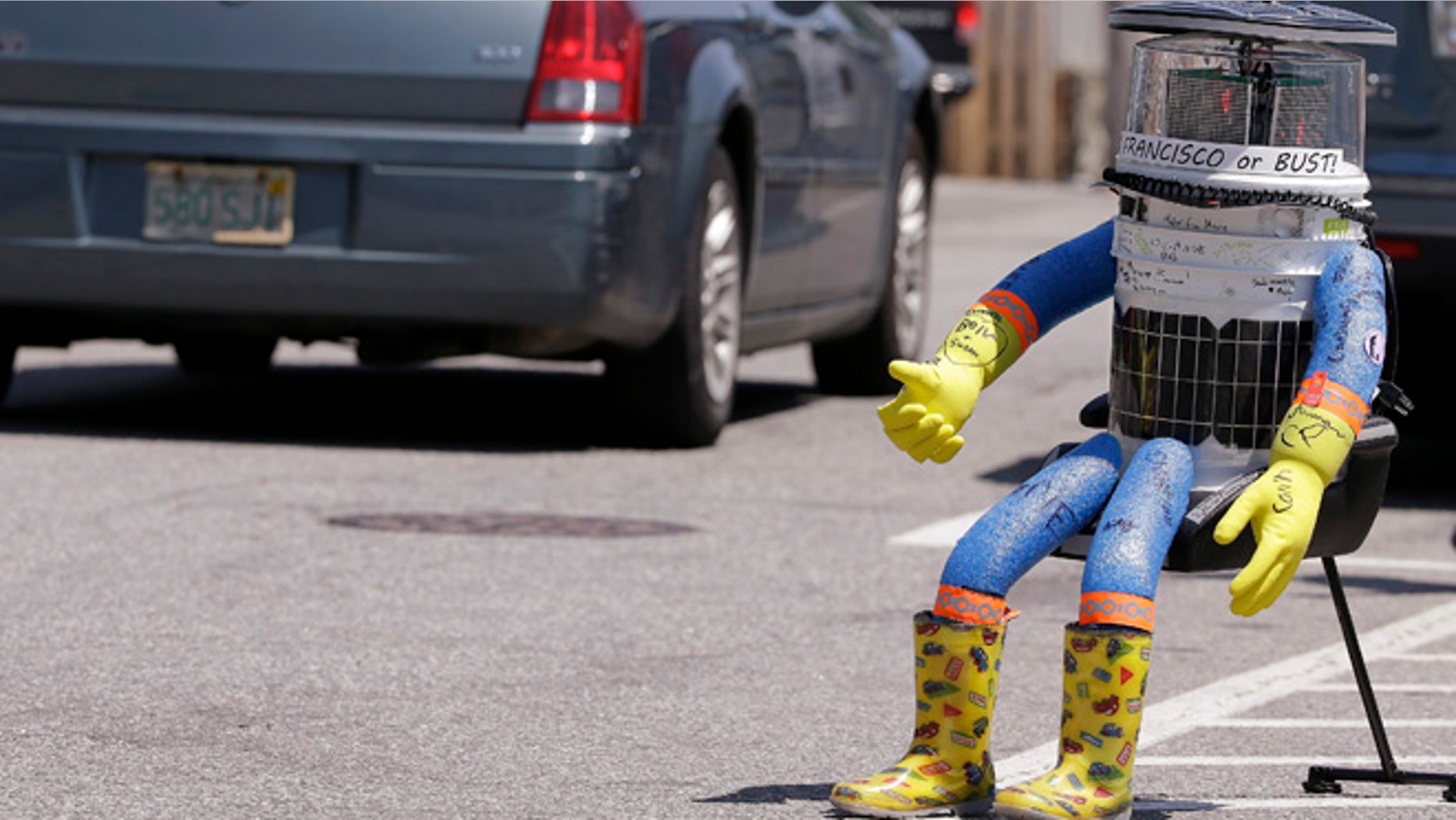 July 17, 2015: A car drives by HitchBOT, a hitchhiking robot in Marblehead, Mass. The Canadian researchers who created hitchBOT as a social experiment say someone in Philadelphia damaged the robot beyond repair on ending its brief American tour. (AP)