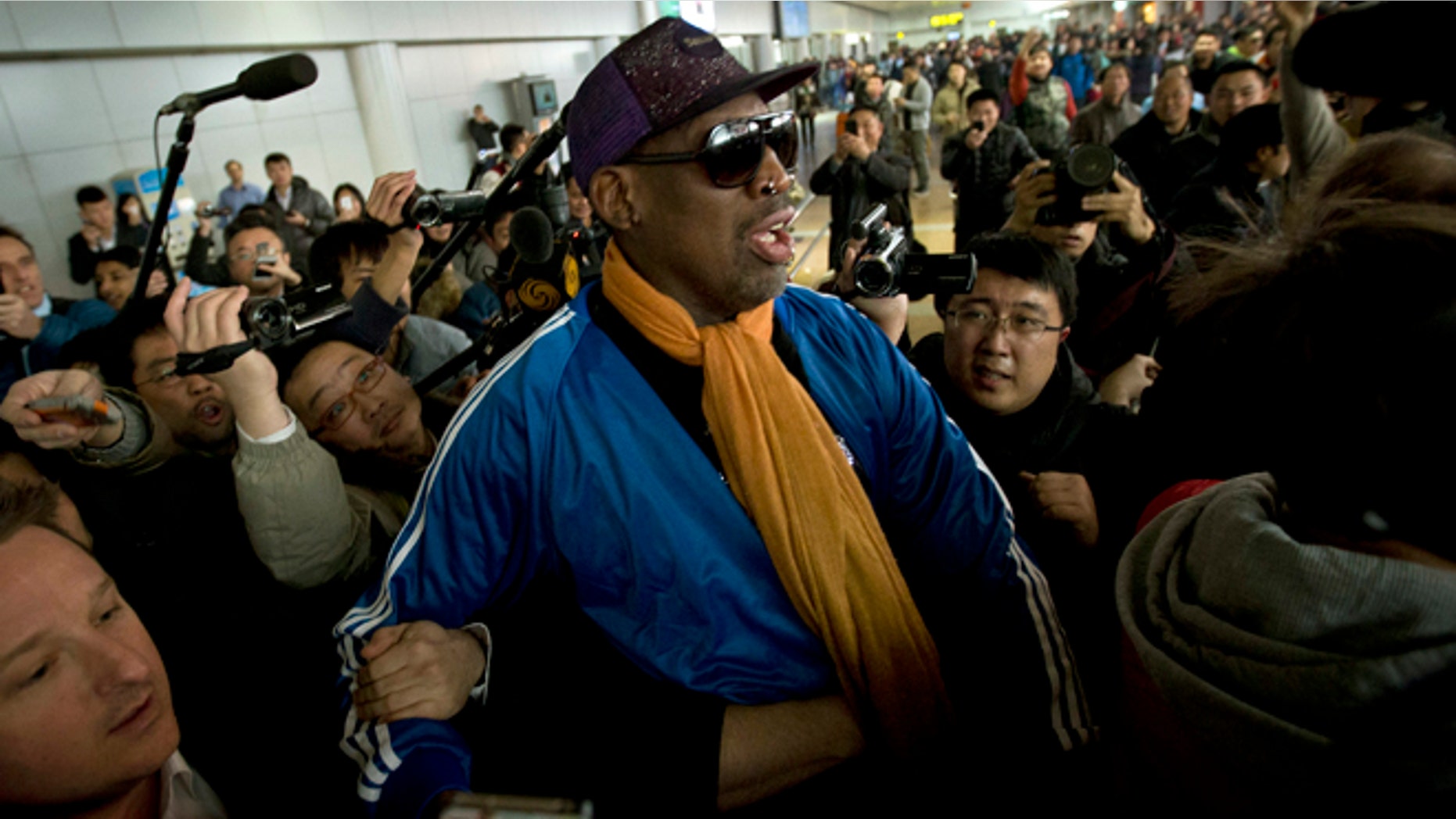 Jan. 13, 2014: Former NBA basketball player Dennis Rodman is followed by journalists as he arrives at the Capital International Airport in Beijing from Pyongyang.