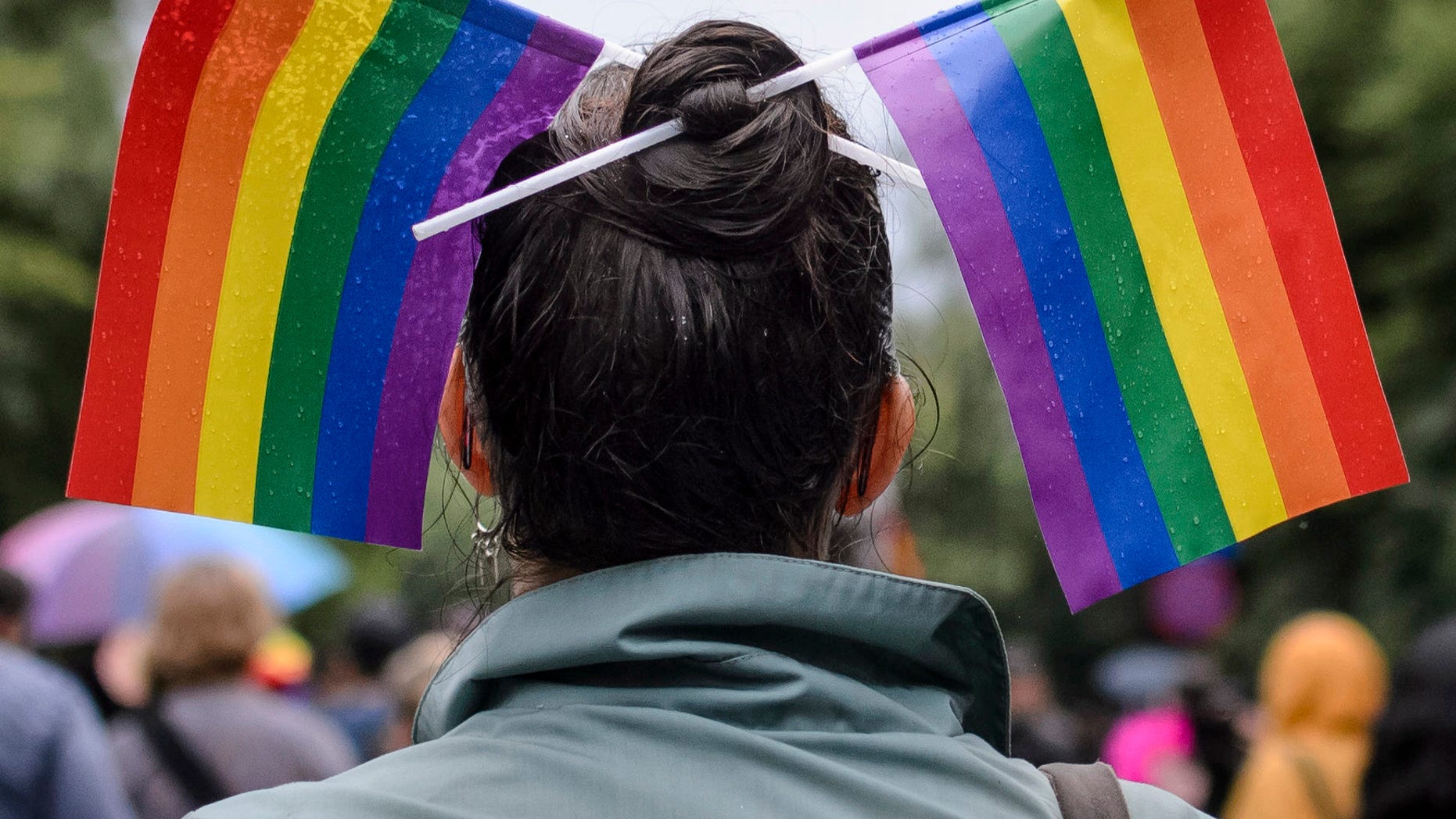 A woman with rainbow colored flags in her hair waits for the start of a gay pride parade in Bucharest, Romania, Saturday, May 20, 2017. Some 1,000 people have joined a gay pride march in the Romanian capital of Bucharest on Saturday, demanding greater rights amid government moves they say will curtail their human rights. (AP Photo/Andreea Alexandru)