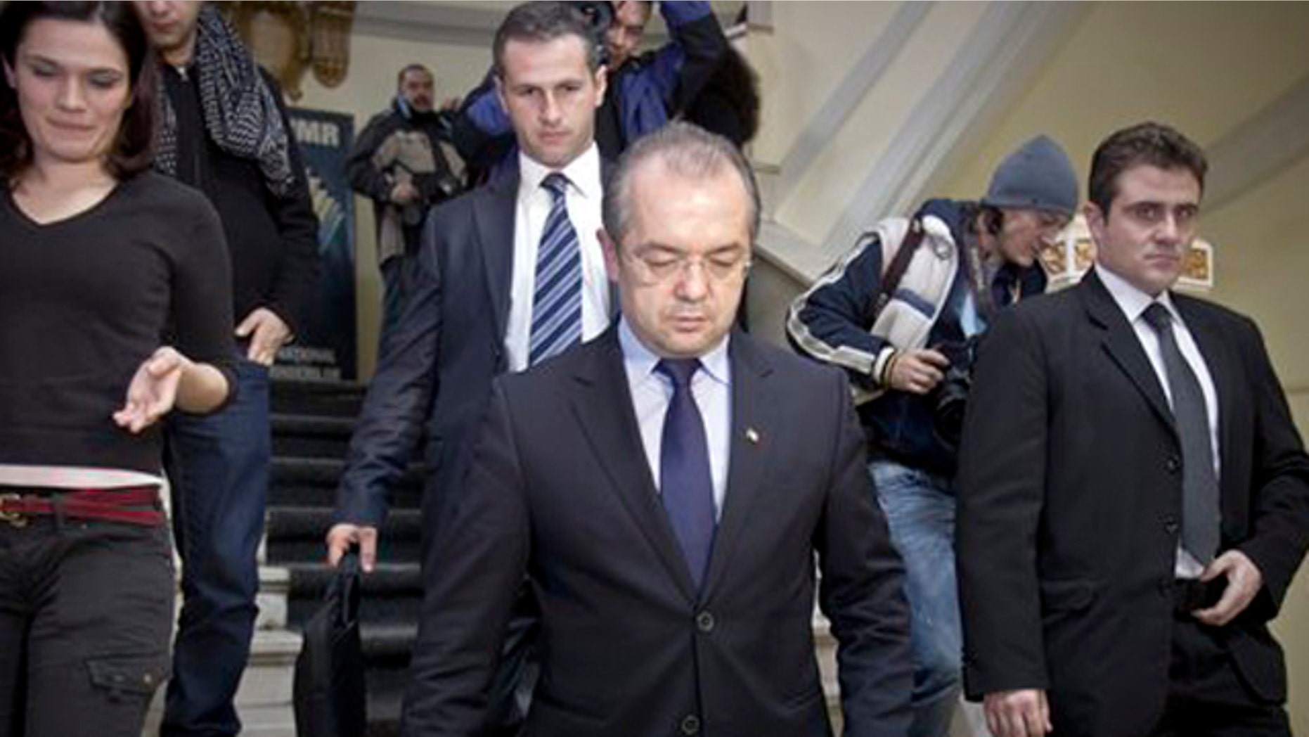 Feb. 6, 2012: Romanian Premier Emil Boc, front center, leaves the headquarters of the ruling Democratic Liberal party in Bucharest, Romania, after announcing his immediate resignation with his government on Monday, saying he wanted to protect the stability of the country.