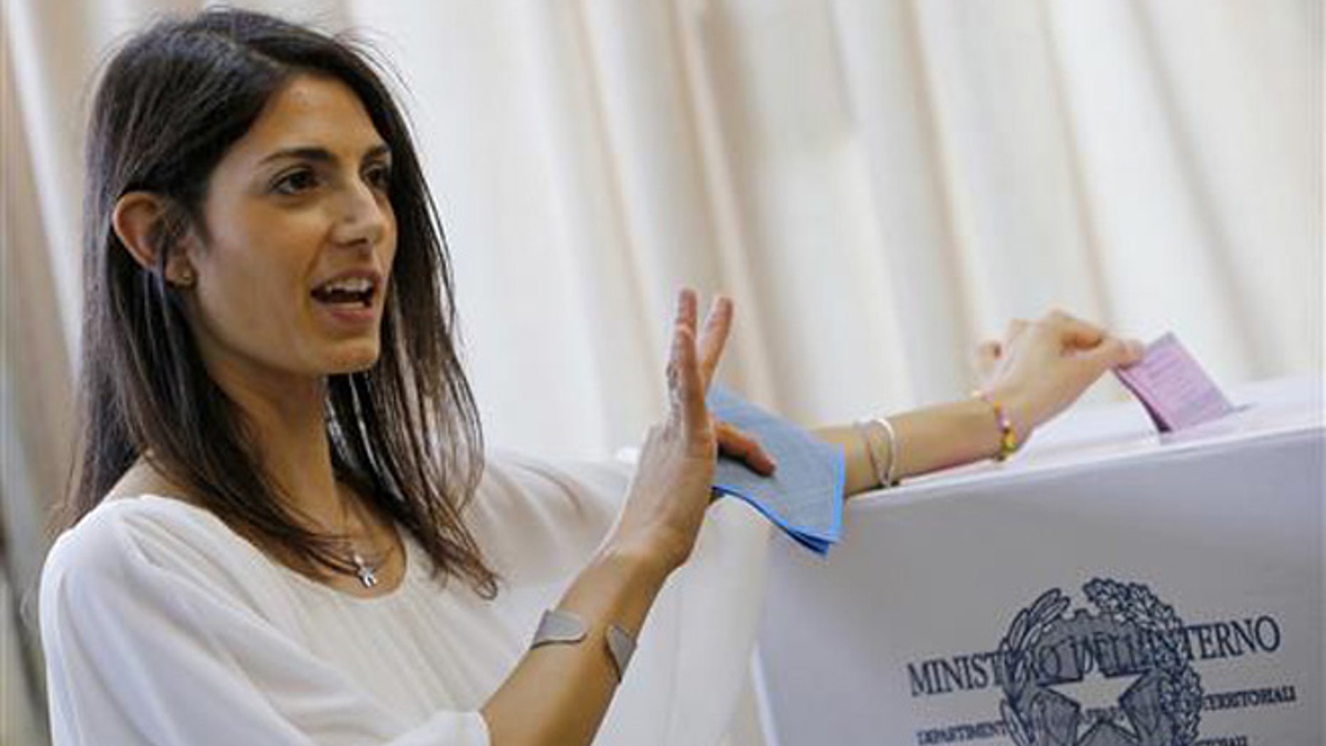Anti-establishment 5-Star Movement (M5S) candidate as Rome's mayor Virginia Raggi poses for photographers as she casts her ballot in polling station in Rome, Sunday, June 19, 2016.