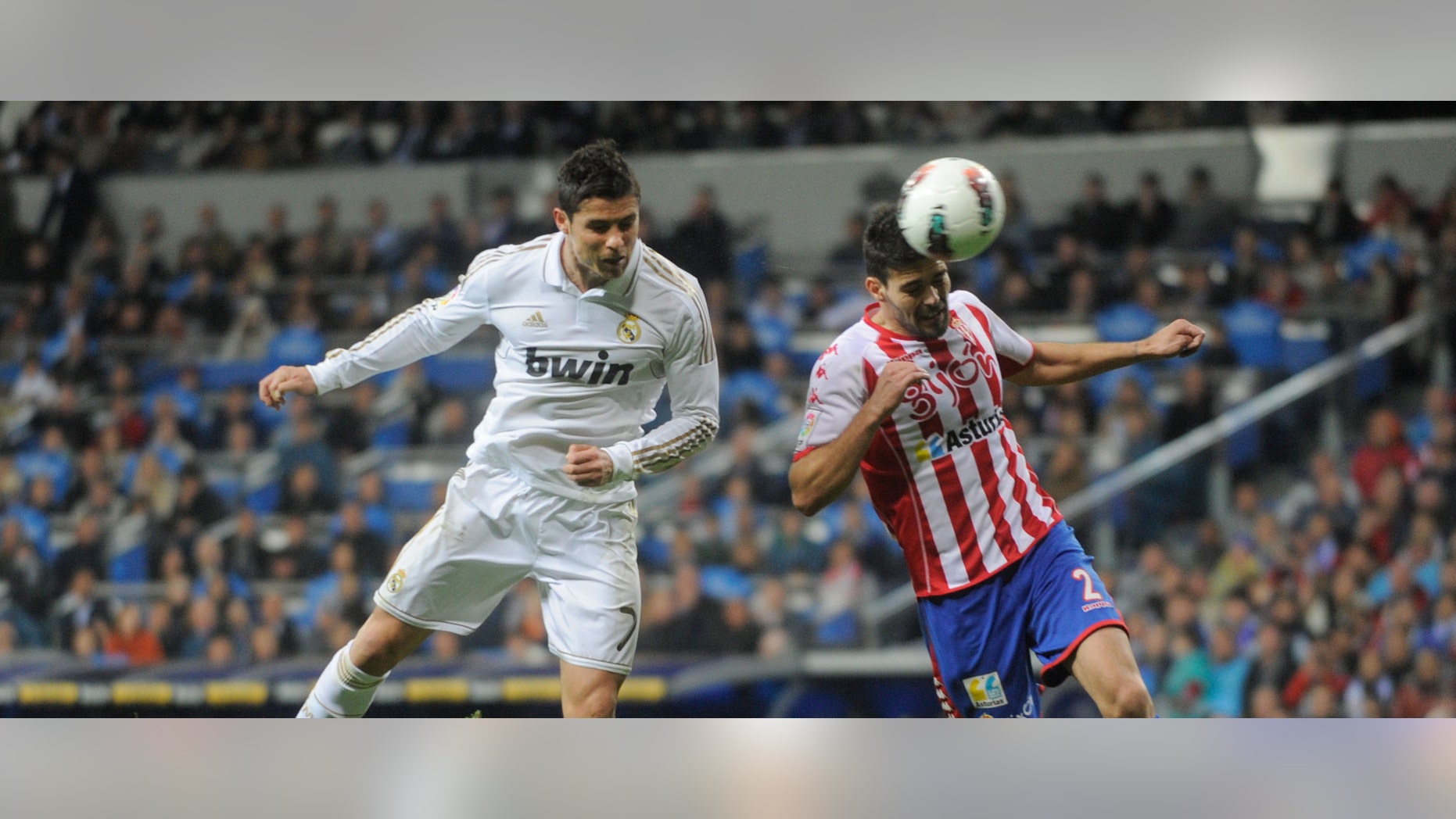 MADRID, SPAIN - APRIL 14: Cristiano Ronaldo (L) of Real Madrid CF beats Alberto Botia to score their second goal during the La Liga match between Real Madrid CF and Real Sporting de Gijon at Estadio Santiago Bernabeu on April 14, 2012 in Madrid, Spain. (Photo by Denis Doyle/Getty Images)