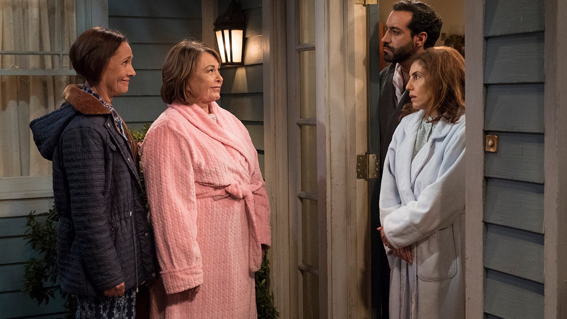 ROSEANNE - "Go Cubs" - The Conners can't pay their Wi-Fi bill, so they befriend their new neighbors to use the internet for Mary to Skype with mom Geena, who is stationed in Afghanistan. Meanwhile, Dan loses an important job and D.J. admits post-military life has been hard, so they come up with a plan to make extra money, on the seventh episode of the revival of "Roseanne," TUESDAY, MAY 8 (8:00-8:30 p.m. EDT), on The ABC Television Network. (ABC/Adam Rose)
SARA GILBERT, ROSEANNE BARR, ALAIN WASHNEVSKY, ANNE BEDIAN
