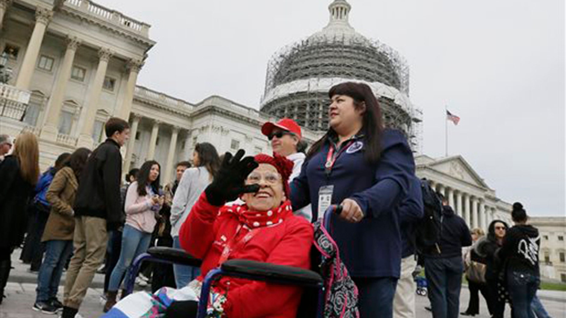 Former Rosie, Cookie Garza, 96, pushed by her granddaughter Stephanie Hagaman, waves on the Capitol grounds, Tuesday, March 22, 2016 in Washington. Seven decades after their we can do it attitude proved invaluable to the Allied victory in World War II, about 30 Rosie the Riveters were honored Tuesday with a visit to Washington. (AP Photo/Carlos Osorio)