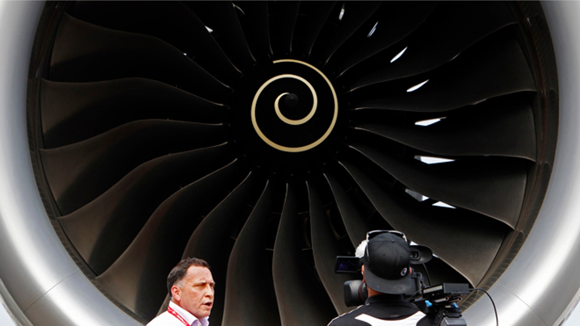 Feb. 11, 2014: Journalists work next to the Rolls Royce engine of an Airbus A350 on display at the Singapore Airshow.