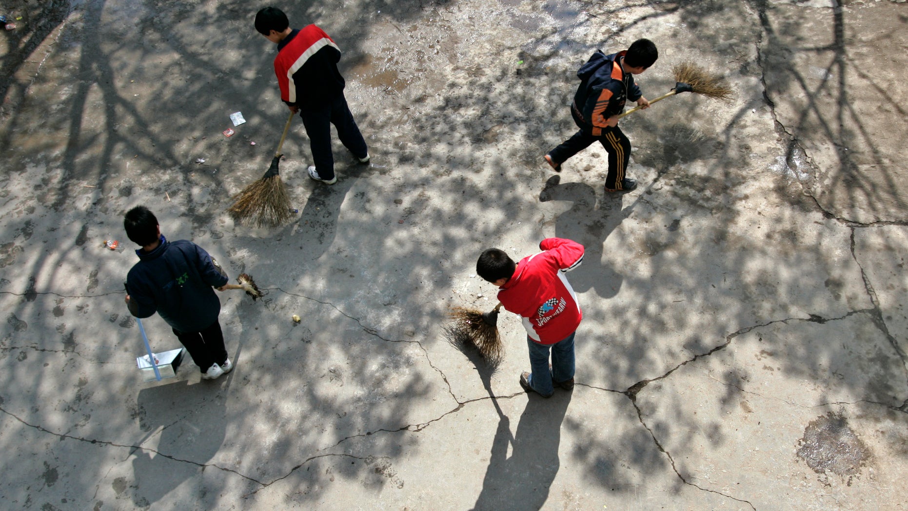 Children sweep the playground at a rural primary school in Nanhui district on the outskirts of Shanghai.