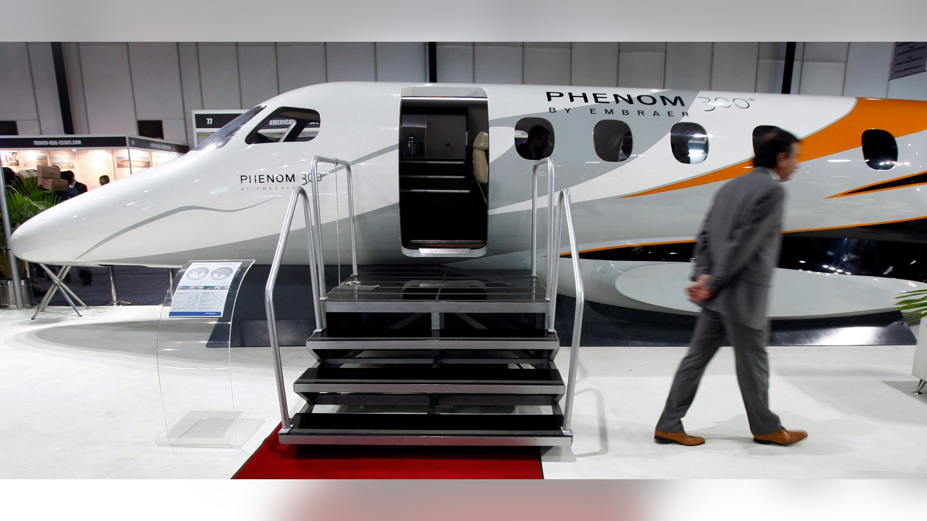 A man walks past a replica of Embraer's Phenom 300 jet at the "Extravaganza 2008 Show" in Mumbai February 23, 2008.