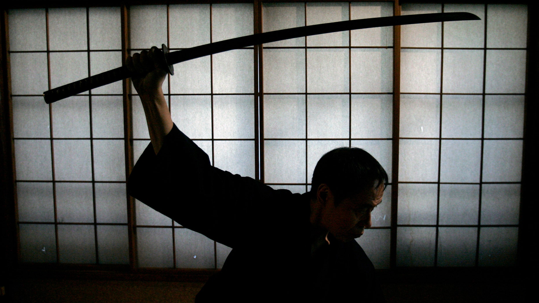 Japanese man holds a samurai sword. (Reuters)