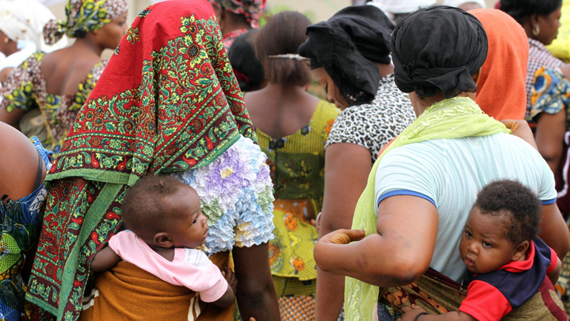 Women carry their children wait for the arrival of U.N. Secretary General Ban Ki-moon for the unveiling of a primary health care clinic in Dutse Makaranta village, on the outskirt of Nigeria's capital, Abuja May 23, 2011. REUTERS/Akintunde Akinleye(NIGERIA - Tags: POLITICS HEALTH) - RTR2MSO1