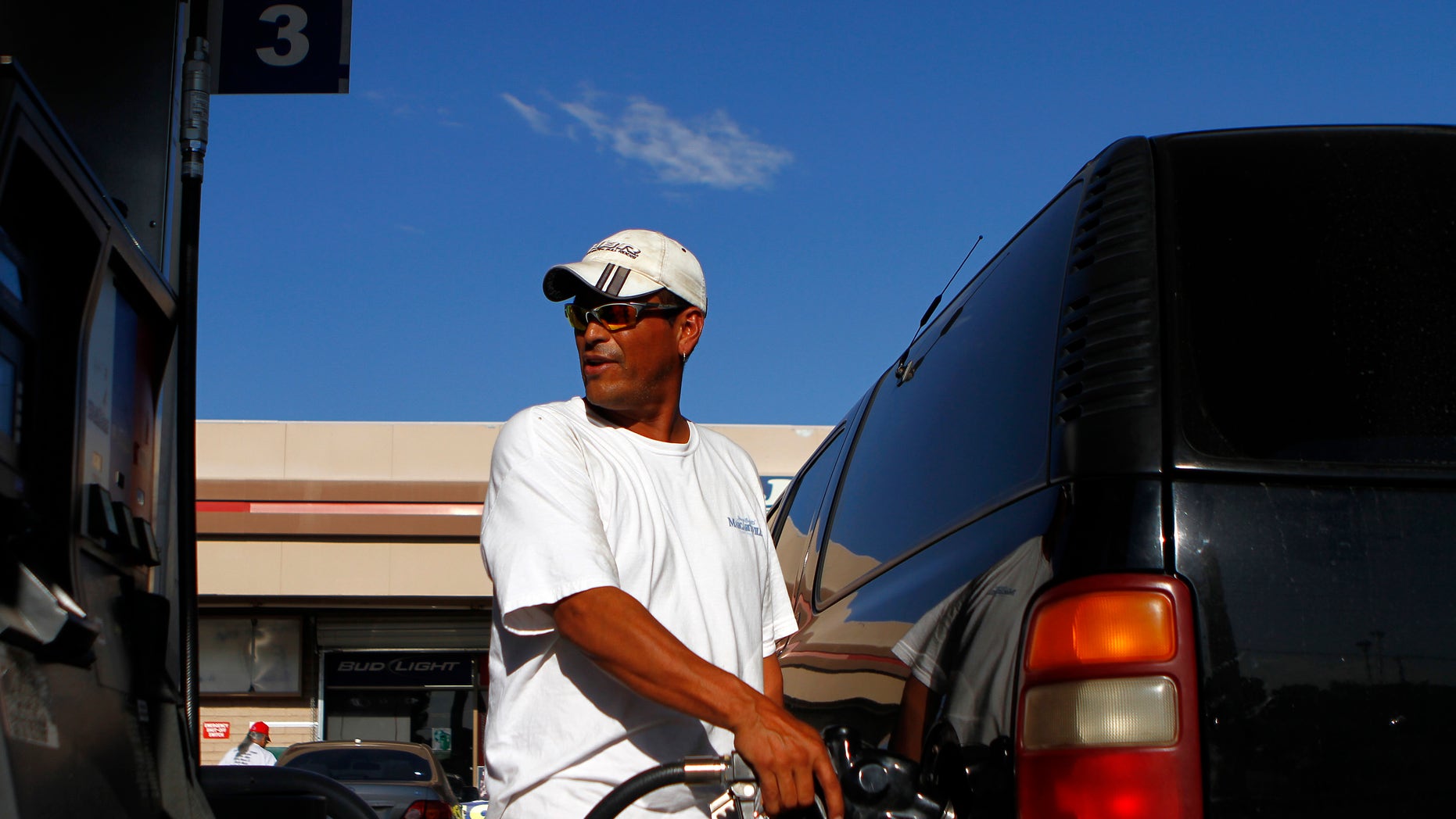 FILE -- August 2011: A motorist pumps fuel into his vehicle at JJ's Express Gas Plus station in Phoenix gas station in Phoenix, Arizona.