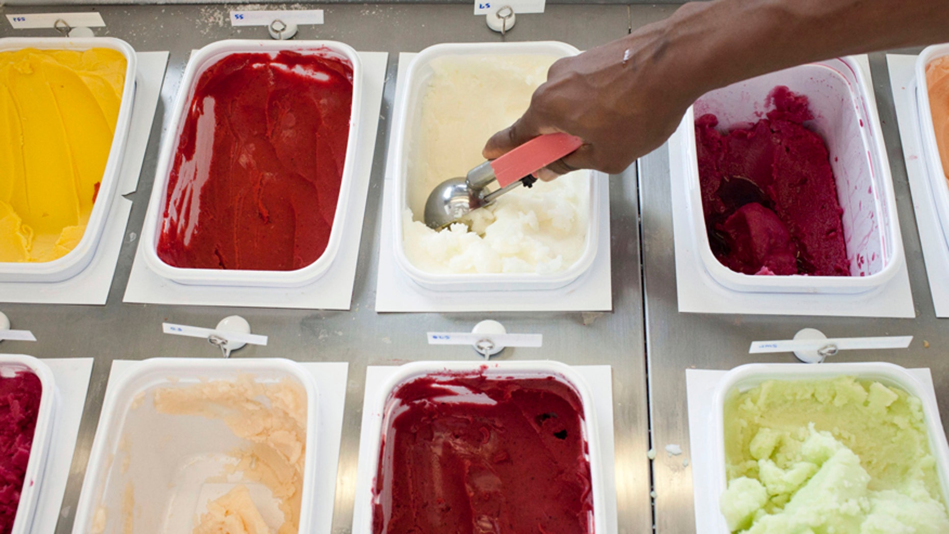 Christina Briscoe scoops ice cream at Il Laboratorio del Gelato, an ice cream shop in New York, July 15, 2012. The third Sunday of every July is National Ice Cream Day in the United States. REUTERS/Andrew Burton (UNITED STATES - Tags: FOOD SOCIETY) - RTR34YWC