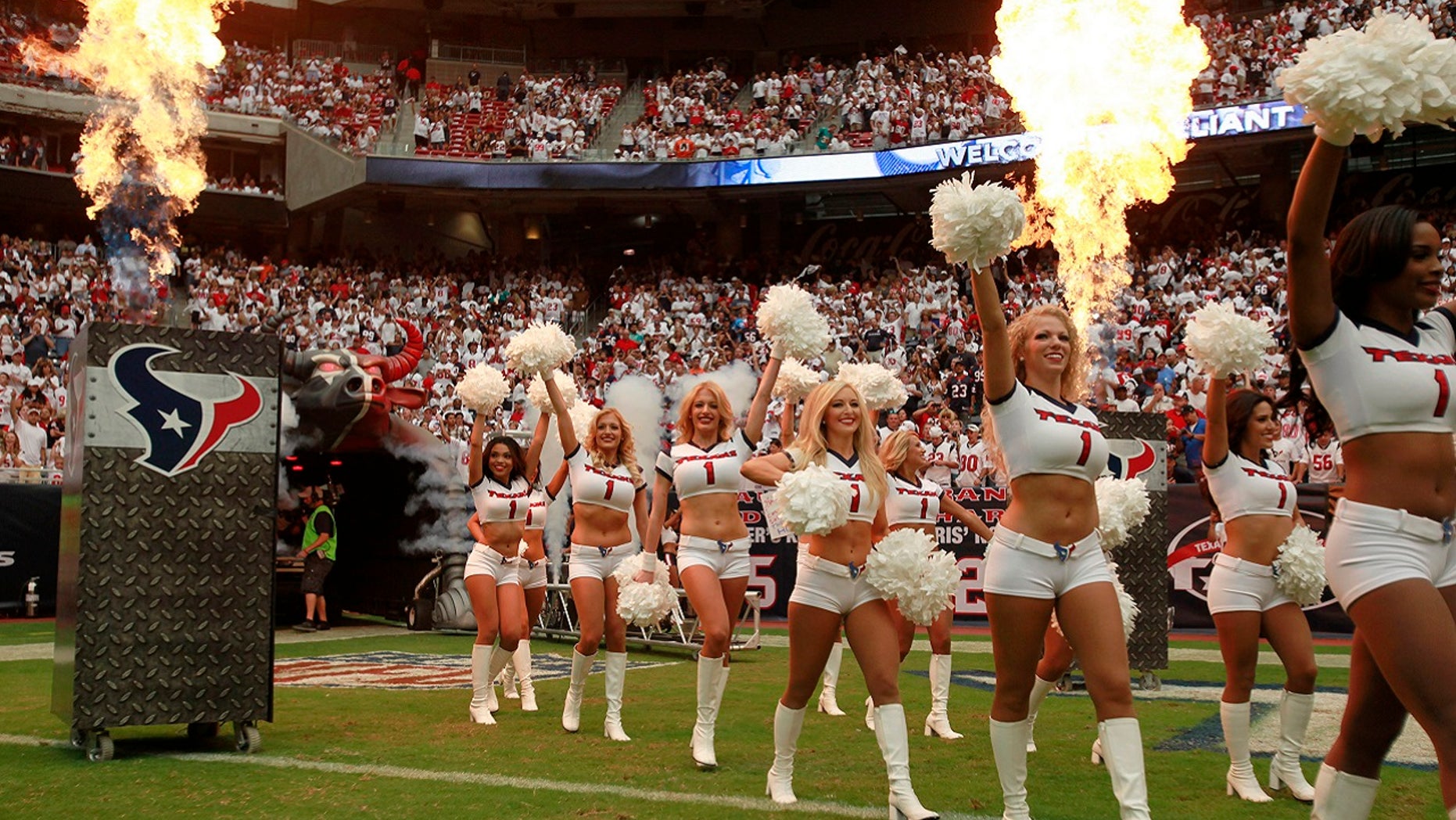 The Houston Texans cheerleaders enter the field surrounded by smoke and flame during the opening ceremonies of the season opening NFL football game against the Miami Dolphins in Houston, Sept. 9, 2012.