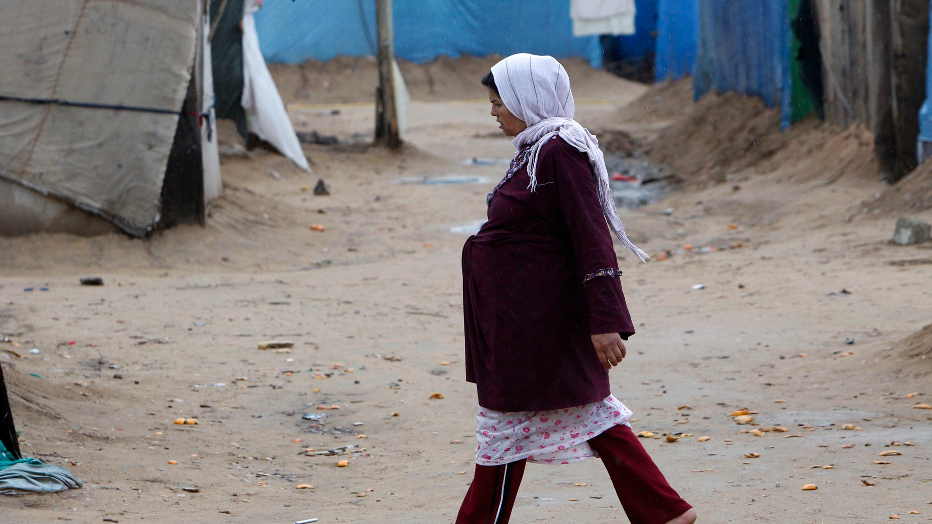 A pregnant Syrian woman walks at a refugee camp in the city of Tyre, in southern Lebanon January 31, 2013. REUTERS/Ali Hashisho