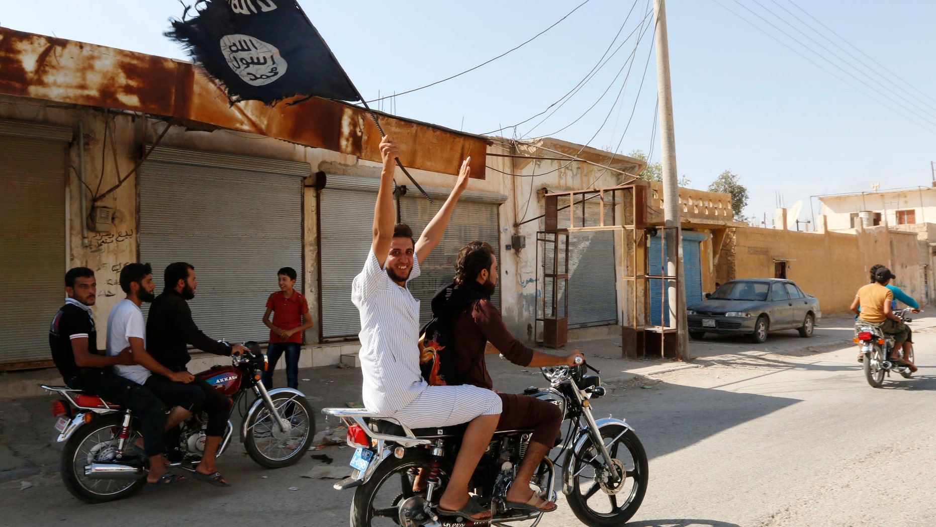 August 24, 2014: A resident of Tabqa city touring the streets on a motorcycle waves an Islamist flag in celebration after Islamic State militants took over Tabqa air base, in nearby Raqqa city. (Reuetrs)