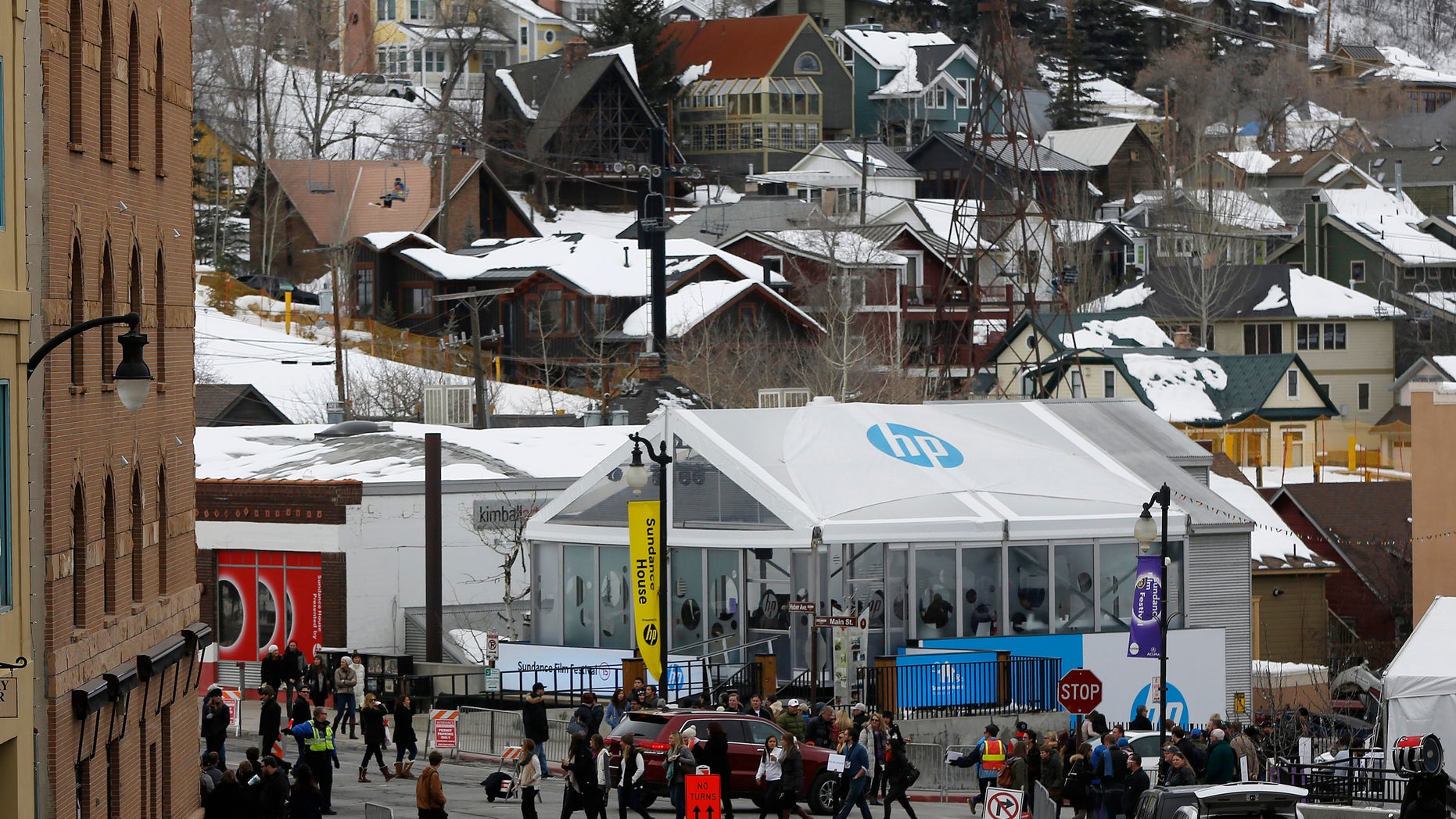 Pedestrians cross the street near skiers on a lift during Sundance Film Festival in Park City, Utah, January 24, 2015.