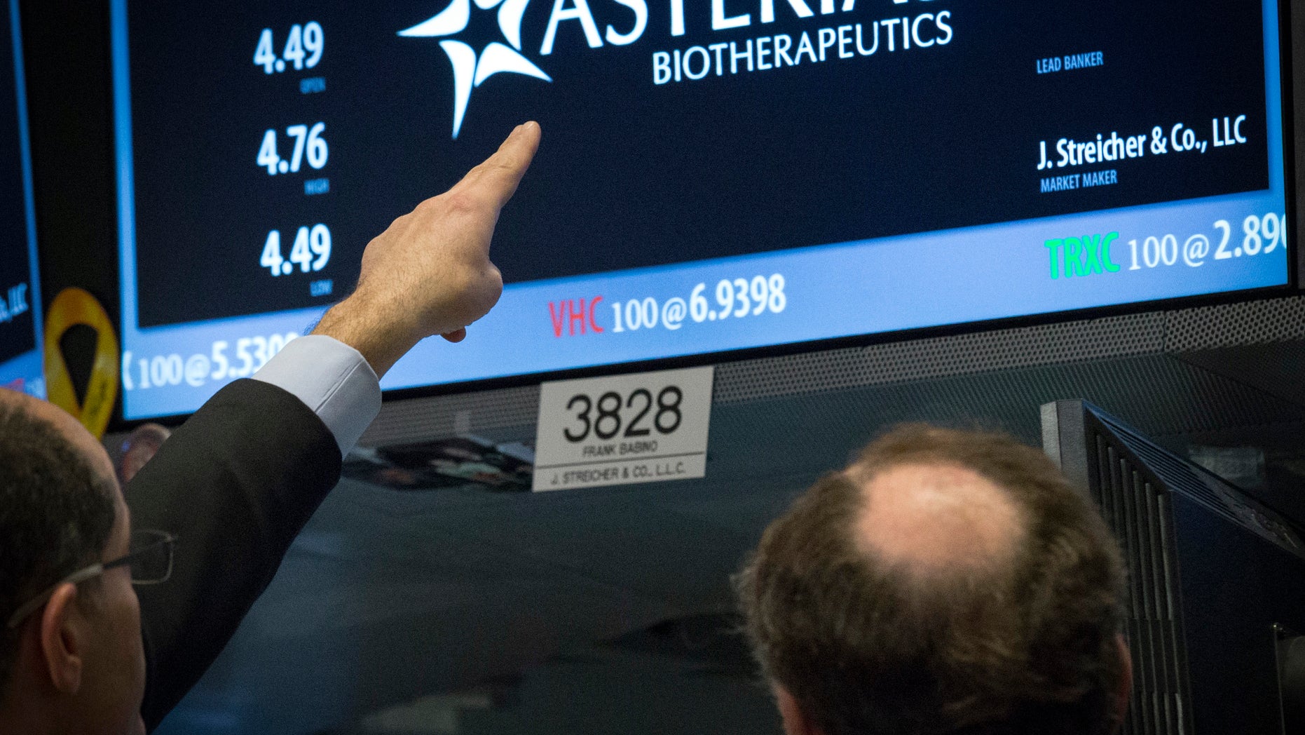 Traders gather at the post that trades Asterias Biotherapeutics, Inc. on the floor of the New York Stock Exchange March 5, 2015. REUTERS/Brendan McDermid (UNITED STATES - Tags: BUSINESS SCIENCE TECHNOLOGY) - RTR4S7OF
