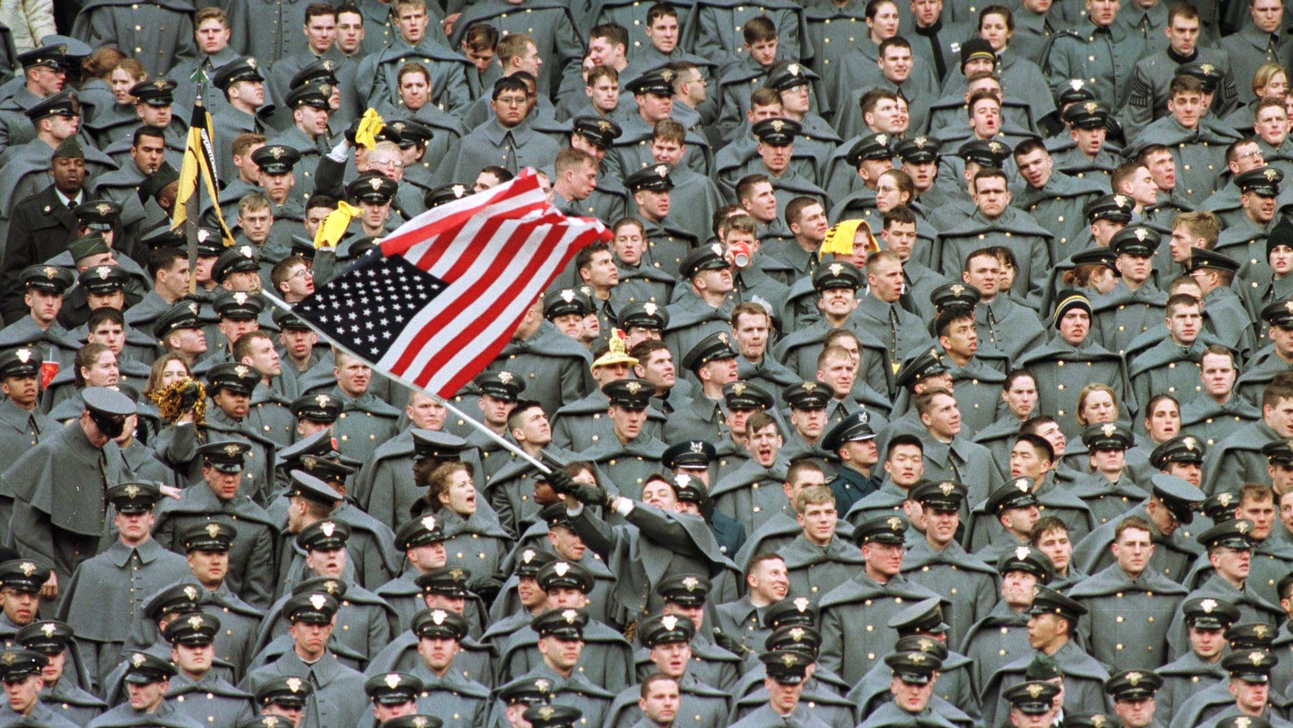 A lone West Point Cadet waves the American flag amid a sea of fellow Cadets as they watch Navy take a commanding lead in the first half of the Army-Navy game, December 6 1997 at Giants Stadium in East Rutherford.