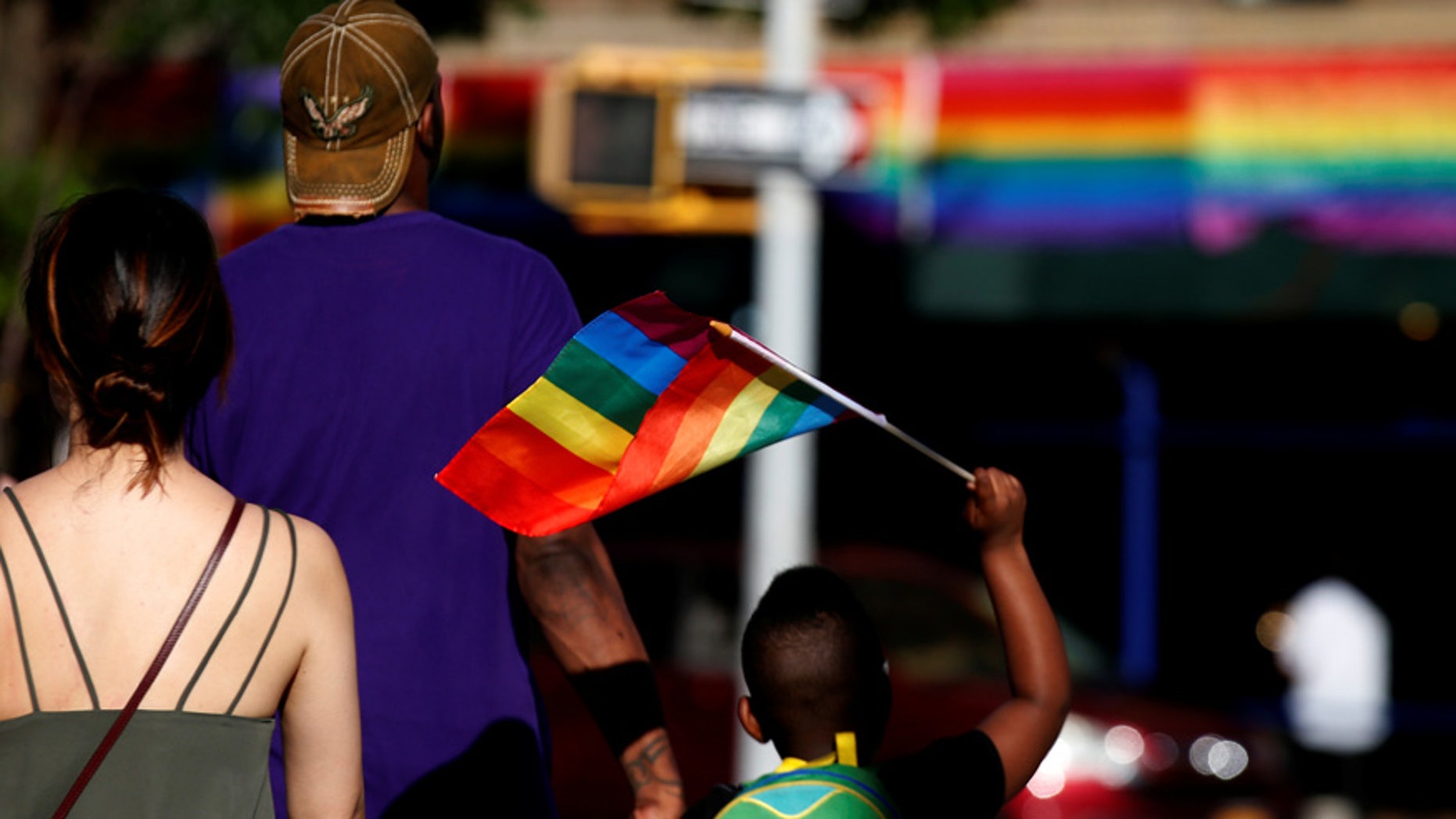 A boy carries a rainbow flag near The Stonewall Inn, on the eve of the LGBT Pride March, in the Greenwich Village section of New York City, U.S. June 24, 2017. REUTERS/Brendan McDermid - RTS18ID1