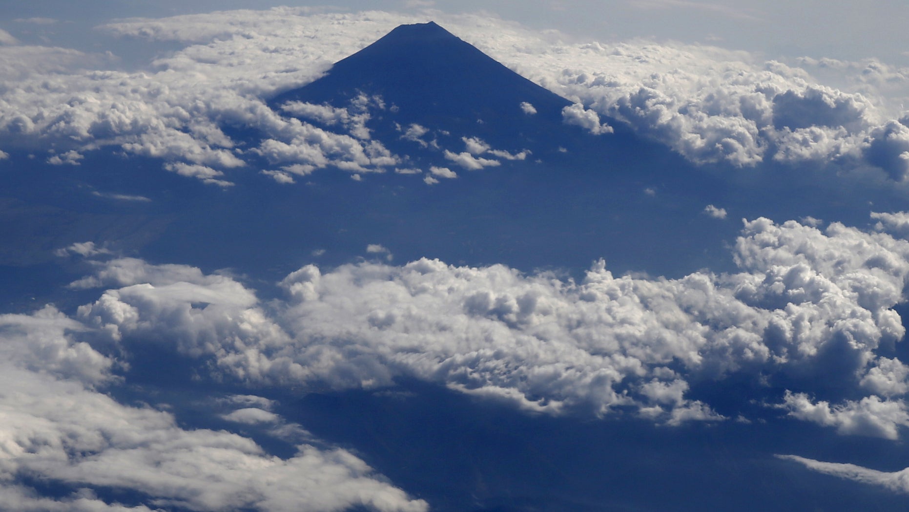 Japan's Mount Fuji, surrounded by cloud, is seen from an airplane October 6, 2015. Mount Fuji, at 3,776 metres (12,388 ft) is Japan's highest mountain. REUTERS/Toru Hanai - RTS3757