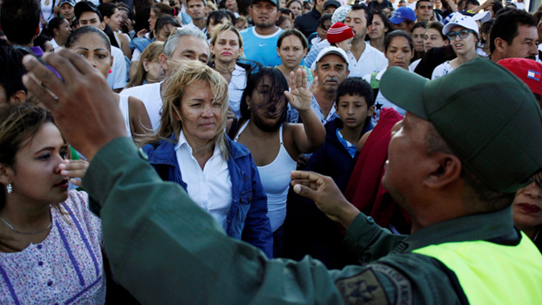 Venezuelan citizens listen to a national guardsman as they try to cross over the Simon Bolivar international bridge to Colombia to take advantage of the temporary border opening in San Antonio del Tachira. (REUTERS)