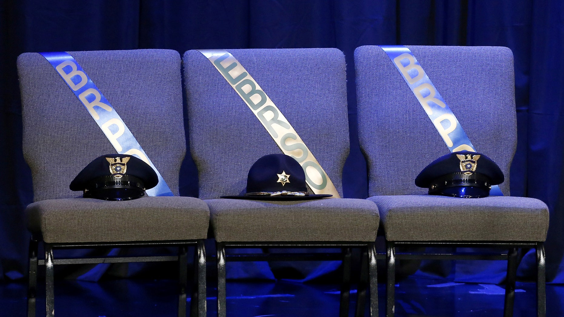 Three chairs honoring the slain Baton Rouge police officers are seen on stage at memorial service at Healing Place Church.
